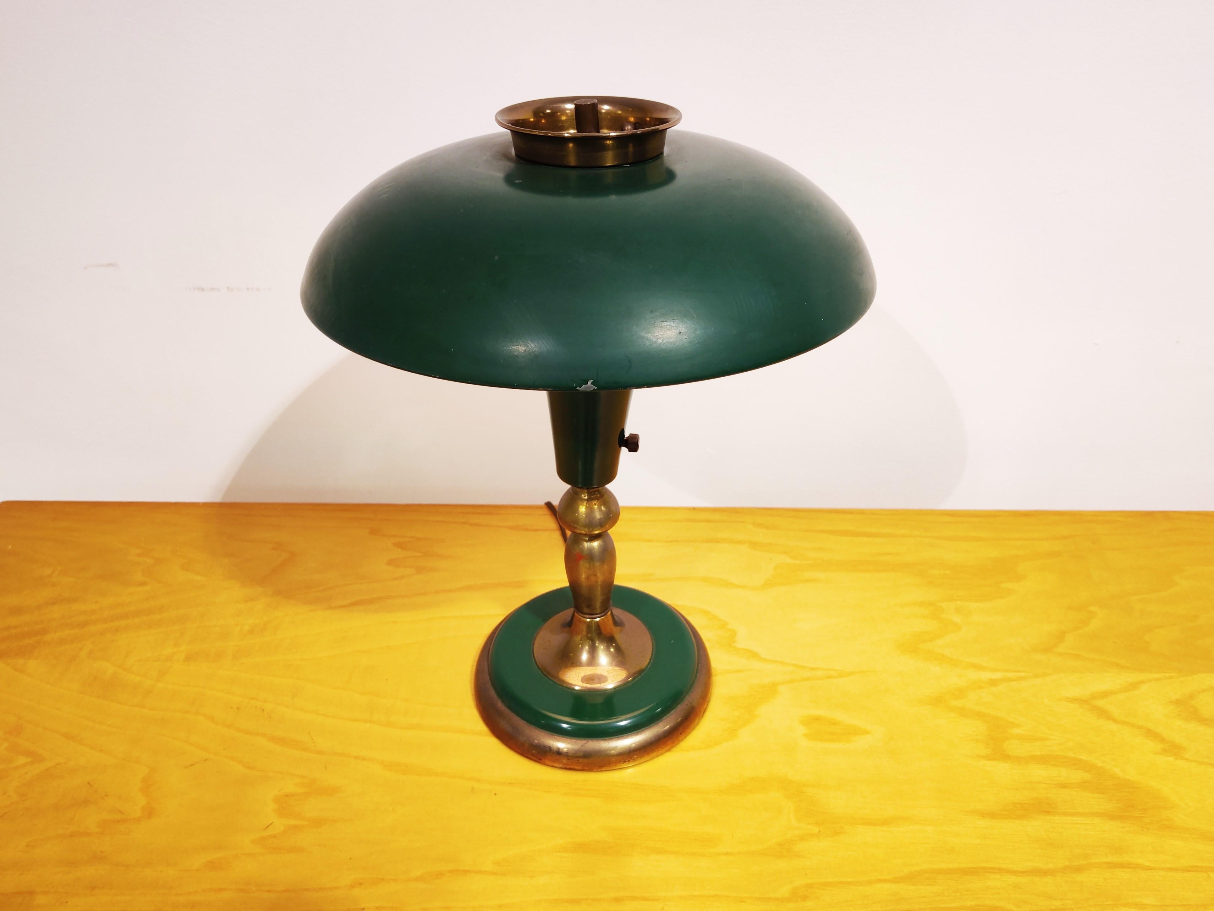 Elegant green metal and brass 'mushroom' Art Deco desk lamp with an adjustable shade. 

Beautiful original condion with patinated brass and the original 'turning' switch.

It takes a small e14 light bulb. Lamp is suitable for use in the usa and