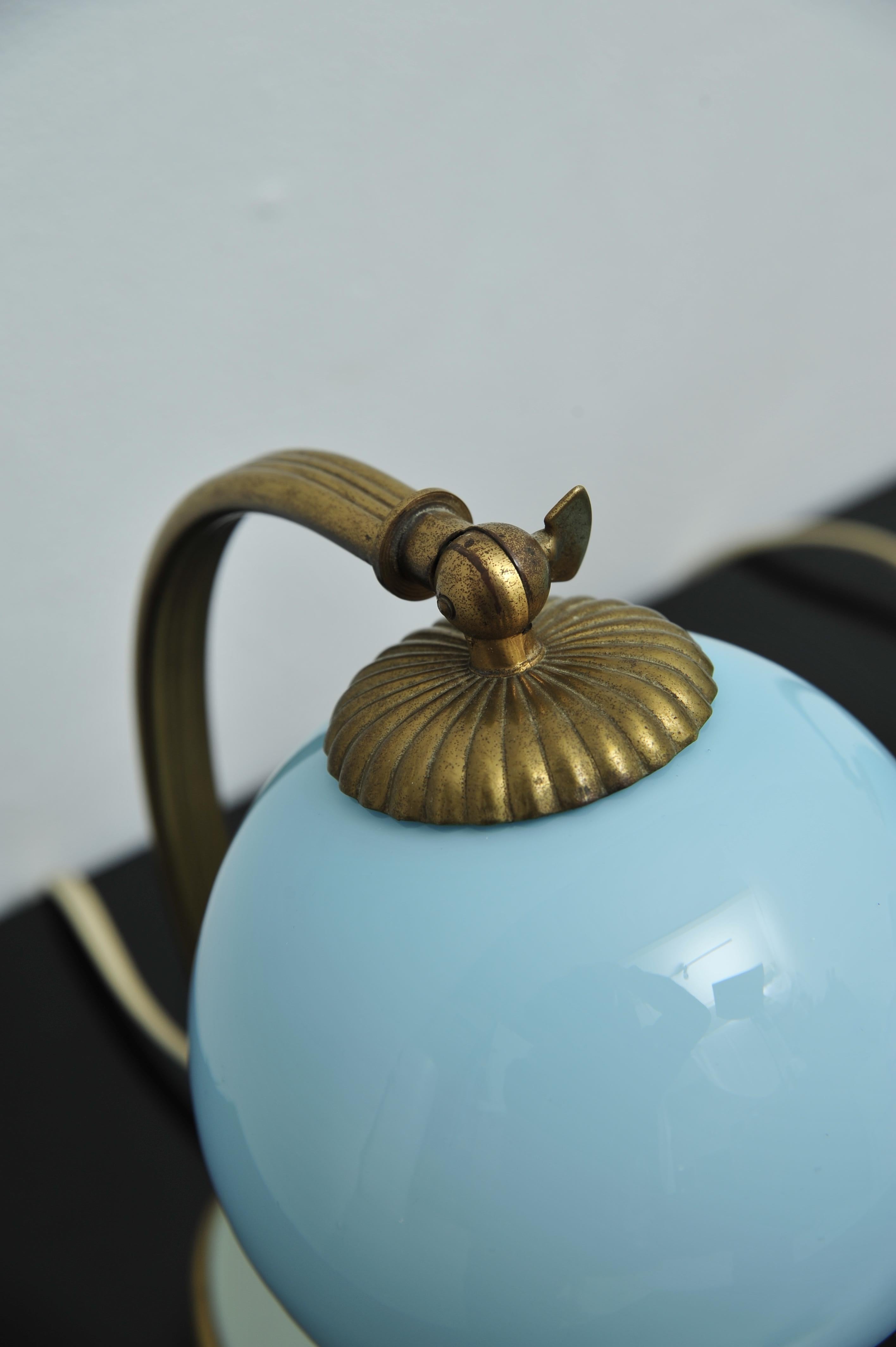 Dieses Set aus zwei eleganten Art Deco Nachttischlampen stammt aus den 1920er oder 1930er Jahren. Die Leuchten verfügen über verstellbare Glasschirme aus originalem blauem Glas und soliden Bronze- oder Messingfüßen mit einem 