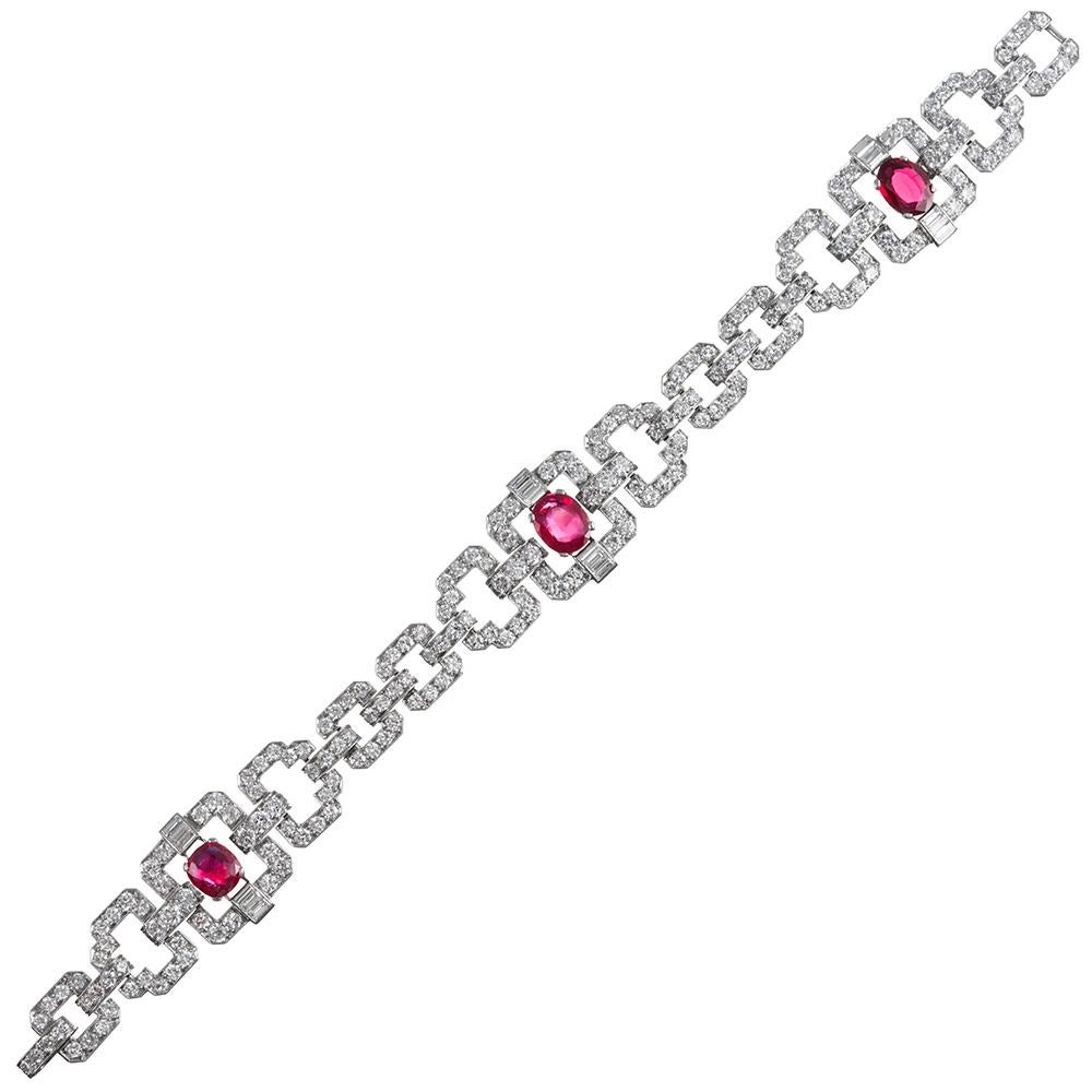 A gorgeous example of art deco splendor, the bracelet is designed of round- and baguette diamond set links with three major faceted oval rubies set at the largest stations. The rubies are described in the accompanying GIA report as being unheated
