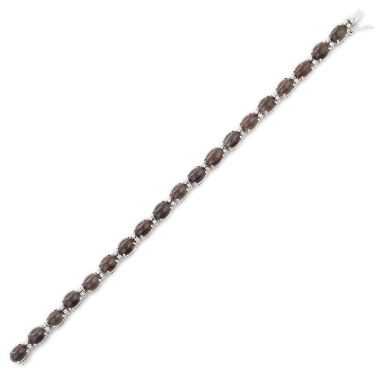 Esta Pulsera de Tenis de Ojo de Gato y Diamantes en oro de 18 quilates exhibe 19 brillantes ojos de gato naturales de 21,8 quilates y 38 piezas de diamantes de 0,45 quilates. Mide 7.25 pulgadas de largo. 
El ojo de gato te da tranquilidad.
Diseñado