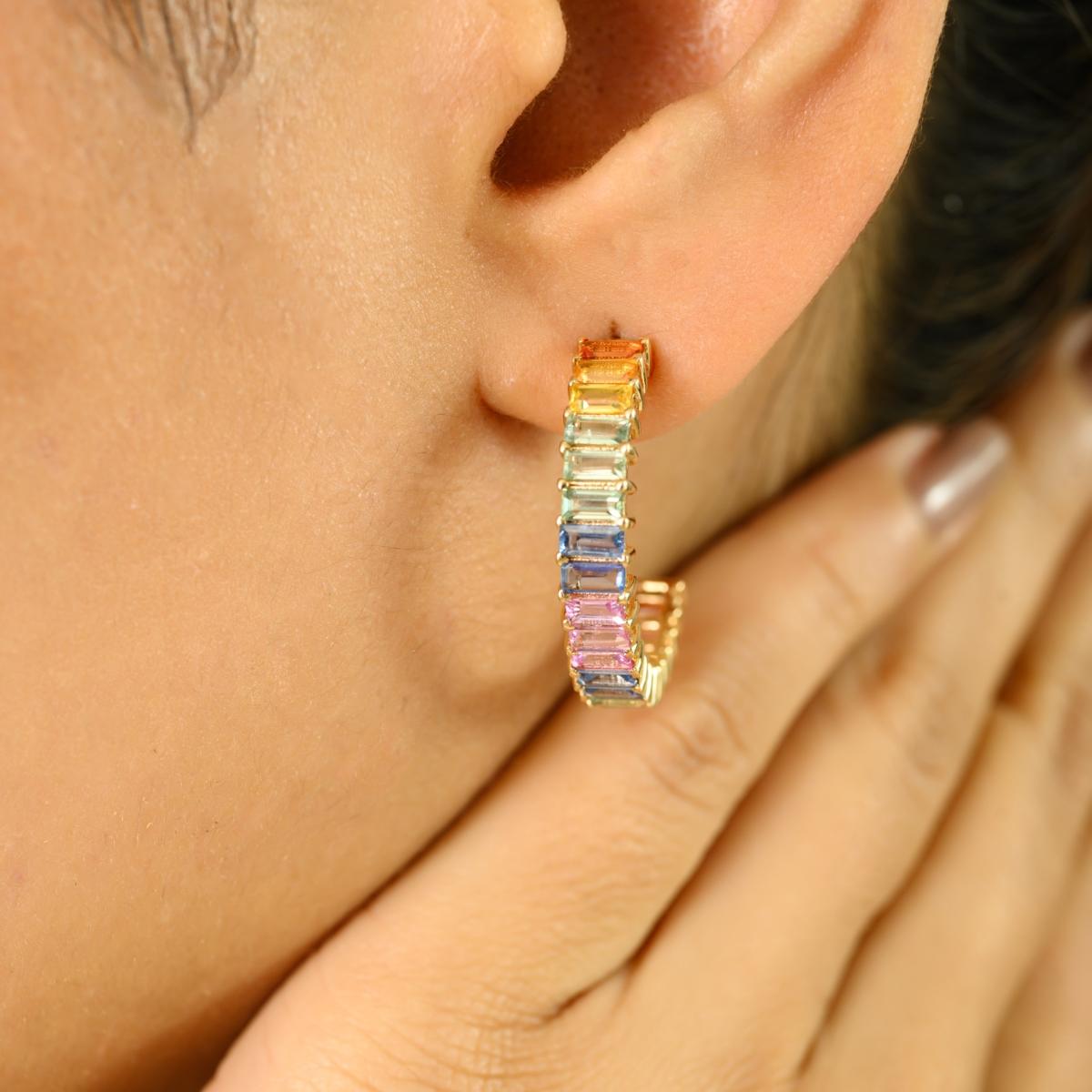 Faites une déclaration vibrante avec ces étonnantes boucles d'oreilles ouvertes en or jaune 14 carats, avec un poids total de pierres de 5,66 carats. Ornées d'un ensemble captivant de pierres précieuses multicolores taillées en baguette, ces boucles