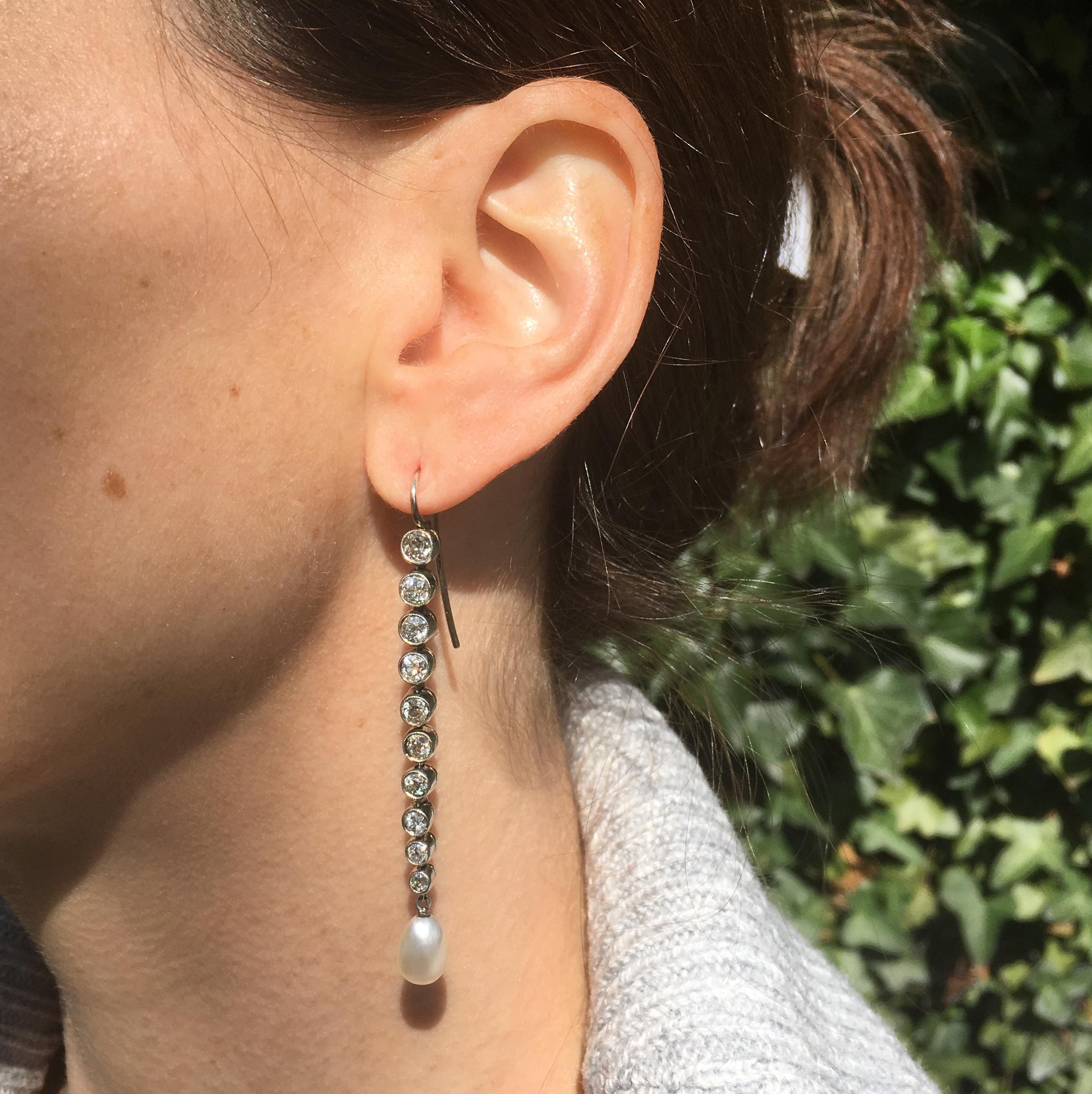 A dazzling and impressive pair of long drop earrings. The ten old cut diamond of graduating size are each set in it’s own milgrained “bezel.” Each earring is fully articulated, and culminating in a creamy and lustrous natural pearl. A