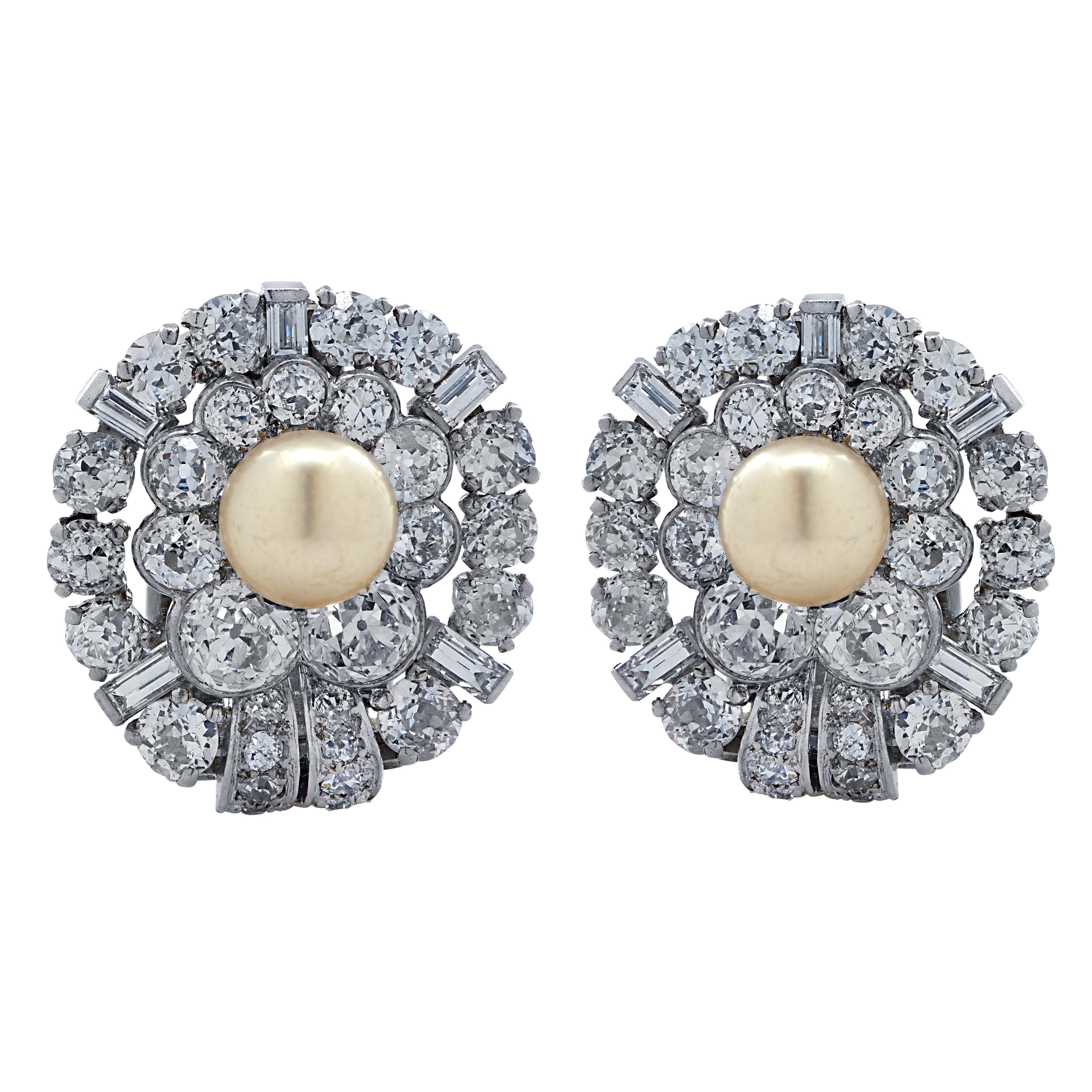 Circa 1930s exquisite clip-on earrings finely crafted in platinum, featuring two Natural Pearls measuring 7 mm in diameter set in a spectacular display of 68 Old European and baguette cut diamonds weighing 7.00 carats total, F-H color, VS-SI