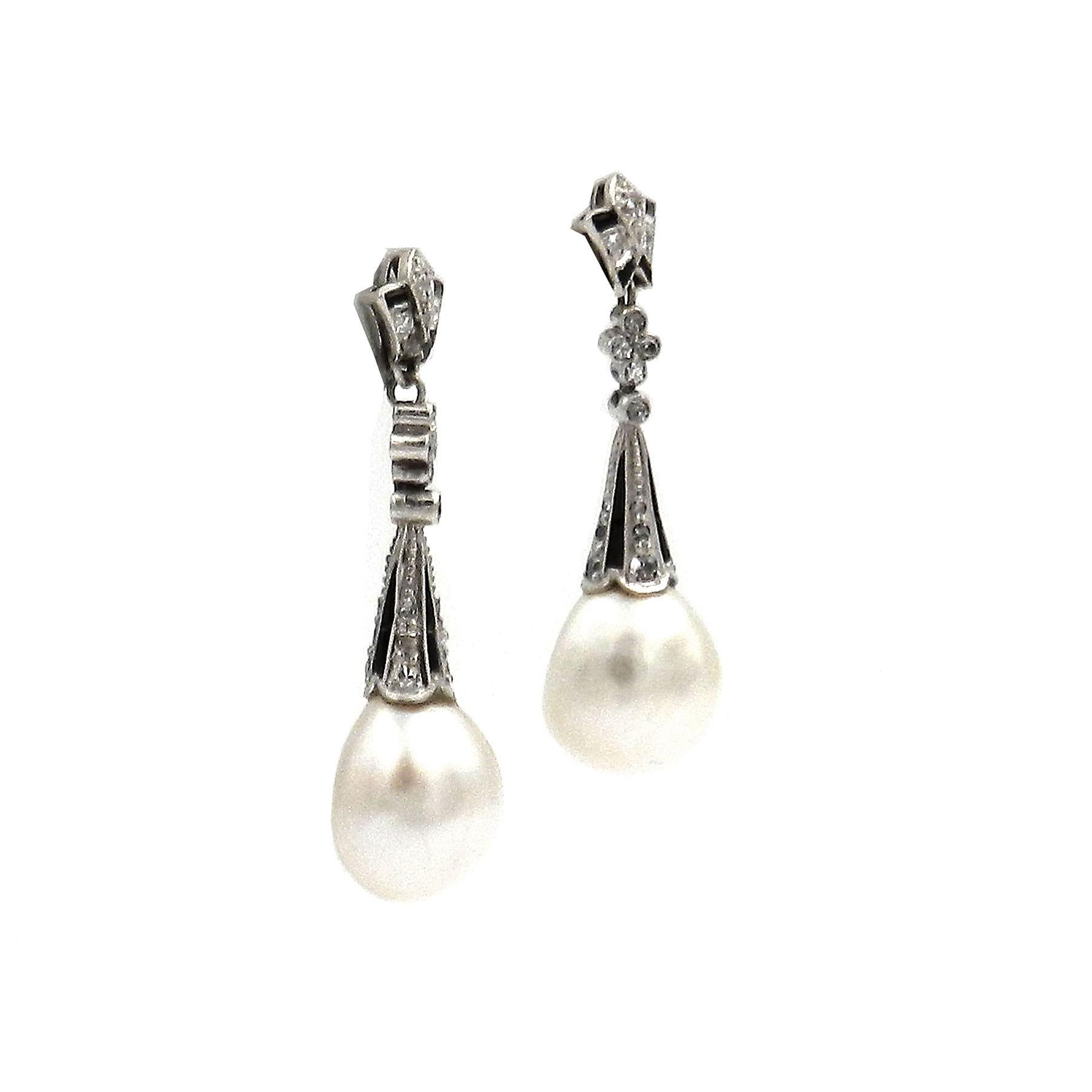 Art Deco Natural Pearl Onyx Diamond 18K White Gold Earrings, circa 1920

Elegant Art Deco earrings, each with a teardrop-shaped natural pearl in an attaché set with onyx triangles and radiant diamonds, movably mounted under a flower-shaped