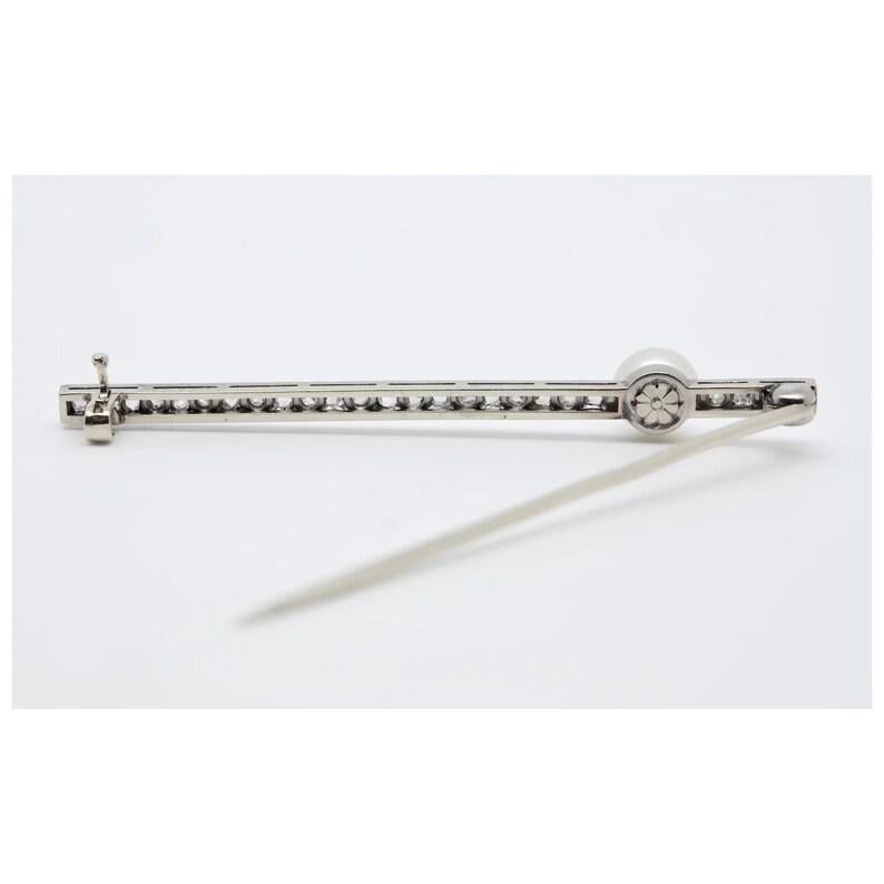 An Art Deco period natural pearl and rose cut diamond brooch in platinum. Centered by a beautiful 5mm diameter natural pearl showing an attractive iridescent milky nacre in excellent condition. Set throughout the brooch are 25 sparkling rose cut