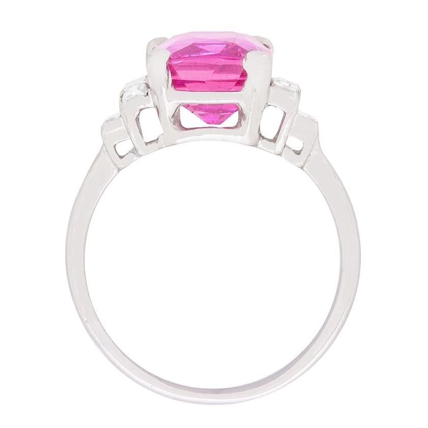 This is a breath-taking ring. It has a simply stunning pink sapphire in the centre weighing 4.57 carat. It is a natural sapphire with no evidence of heat treatment which is certificated by The Gem and Pearl Lab in London. On the shoulders are