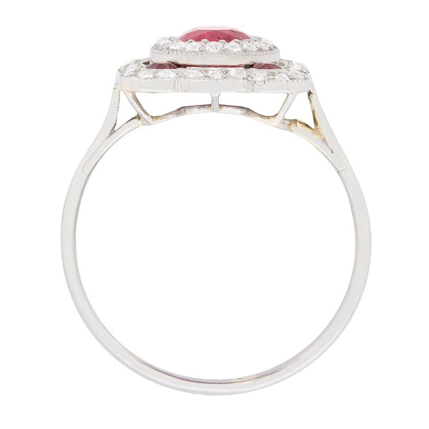 A fabulous red ruby sits in the centre of this ring and weighs 0.90 carat. It is a natural ruby originating from Burma. Surrounding the wonderful gemstone is a halo of sparkling diamonds, the same with the second halo. The diamonds are G in colour