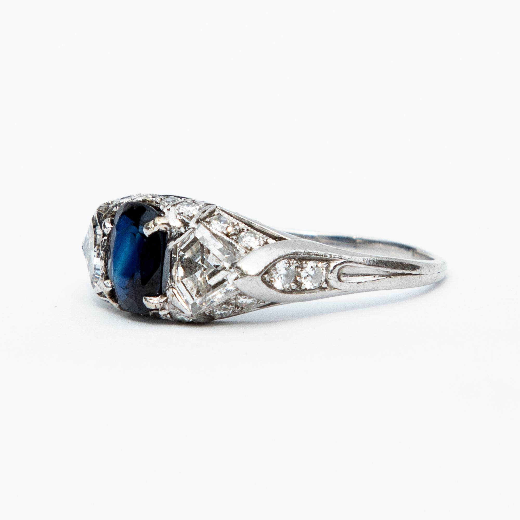 A stunning American origin, Art Deco natural sapphire and diamond three stone ring set in platinum. The wonderful certified 1.3 carat point natural sapphire is flanked by two triangular tapered diamonds and beautifully mounted with a gallery of