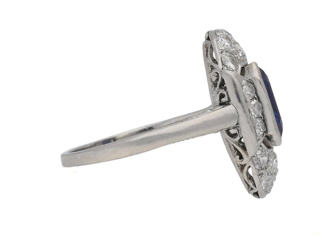 Art-Deco-Ring mit Saphir und Diamant. In der Mitte ein rechteckiger, natürlicher, ungeschliffener Saphir im Smaragdschliff mit einem Gewicht von ca. 2,10 Karat, umgeben von vierzehn runden, altgeschliffenen Diamanten in offener Kornfassung mit einem