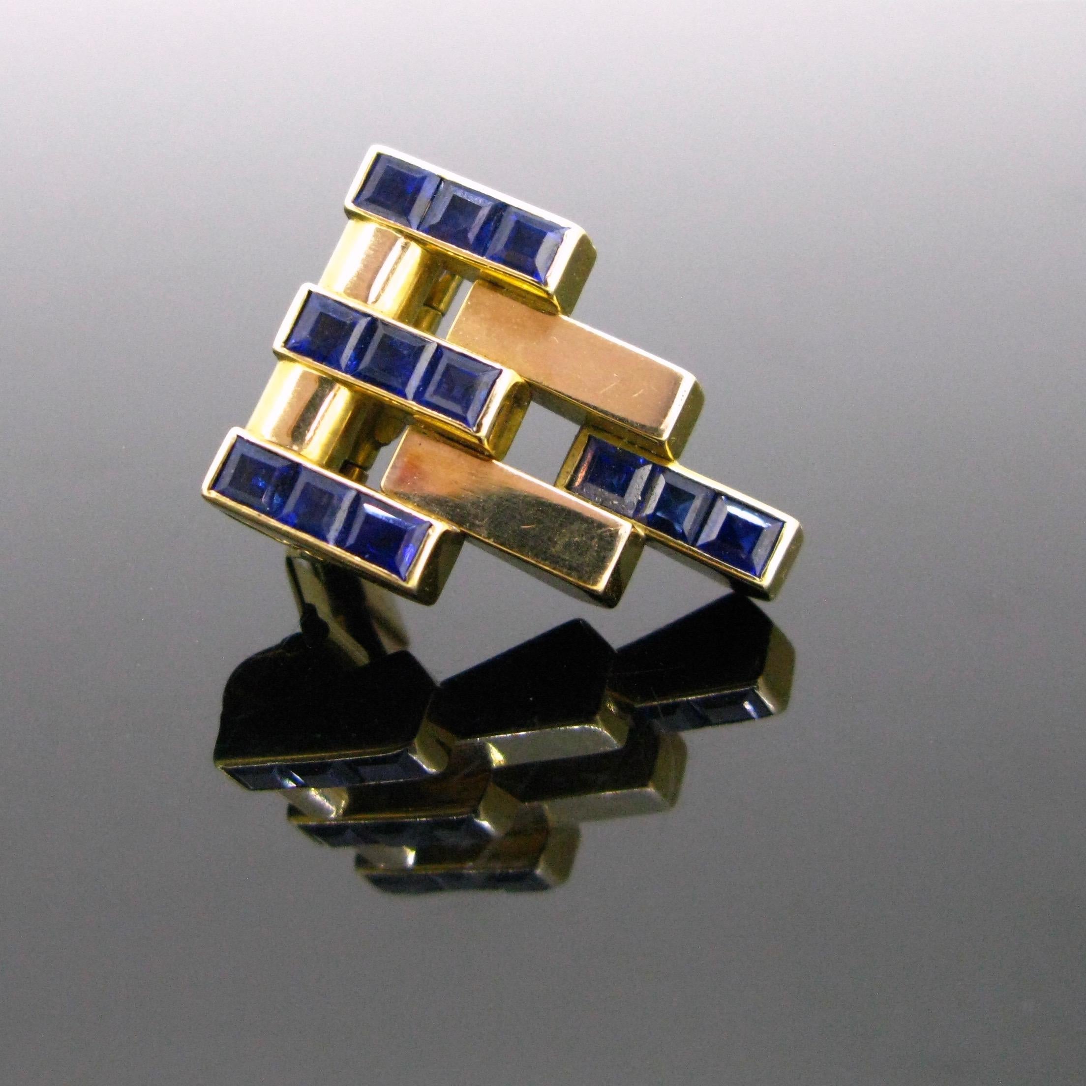 This ravishing clip comes directly from the Art Deco era, circa 1925. It has a geometric design, 4 lines are set with 3 calibrated naturals sapphires. They have a deep blue colour. The yellow gold is smooth and shiny. The back is engraved: ME PE WO