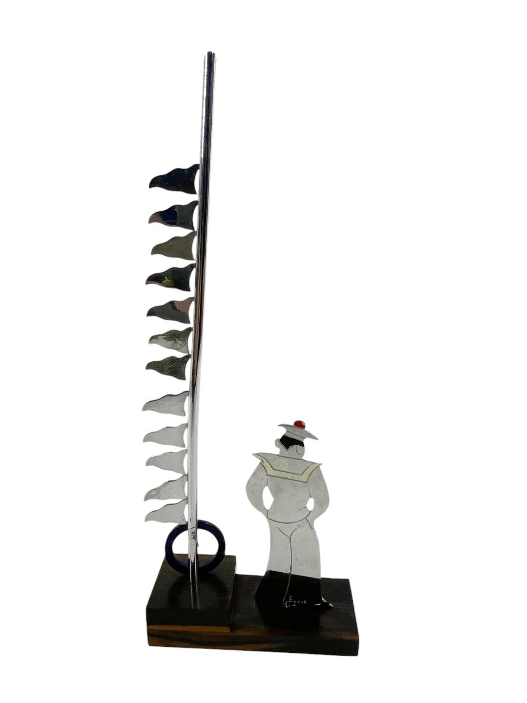 Art Deco drink markers, a sailor in chrome with painter details standing on a tiered wood base next to a life preserver and flagpole with 12 flags each representing a different country. Marked 