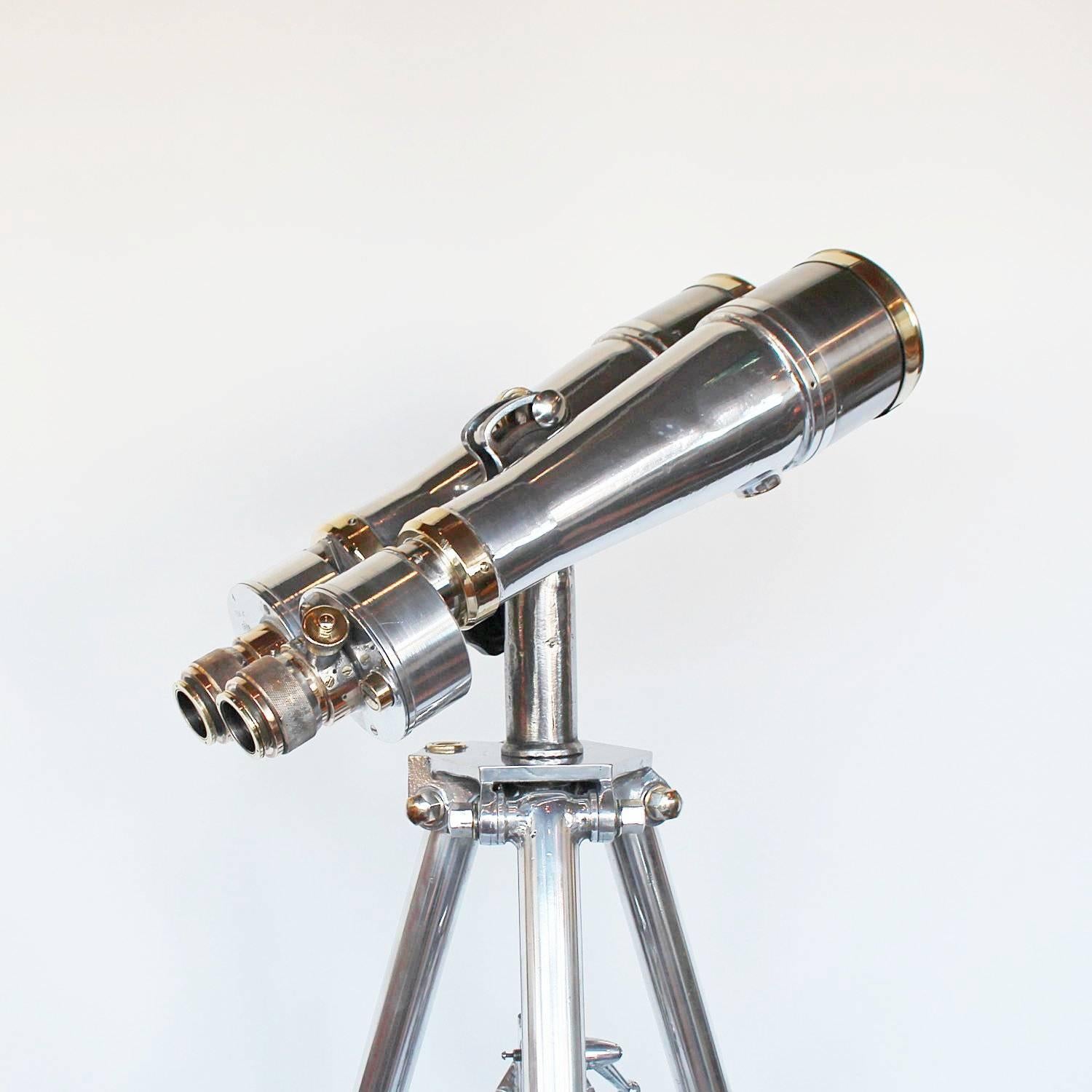 A pair of Fuji Meibo marine binoculars. 15x magnification.

DIMENSIONS: Height with stand 1-2metres , barrel L 35 cm, total L 47cm, W 22 cm

Set over an adjustable, polished metal tripod stand with integral ball and socket foot pads. With original