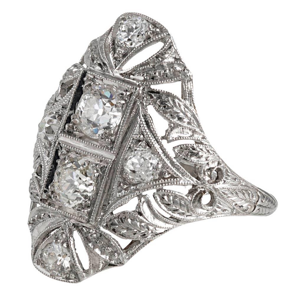 A classic filigree navette ring crafted in platinum and enhanced with six white old European cut diamonds that weigh approximately 1.10 carats in total. The milgrain and detailed engraving appear as small diamonds, the pattern glittering in the