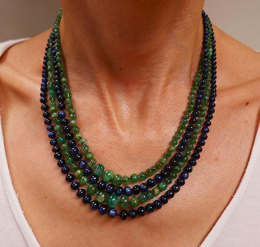          A beautiful Art Deco necklace featuring emerald and sapphire beads. This lovely vintage necklace is equipped with an opal and cushion cut diamond platinum clasp.
	The necklace comprises four bead strands connected by the clasp. Two emerald