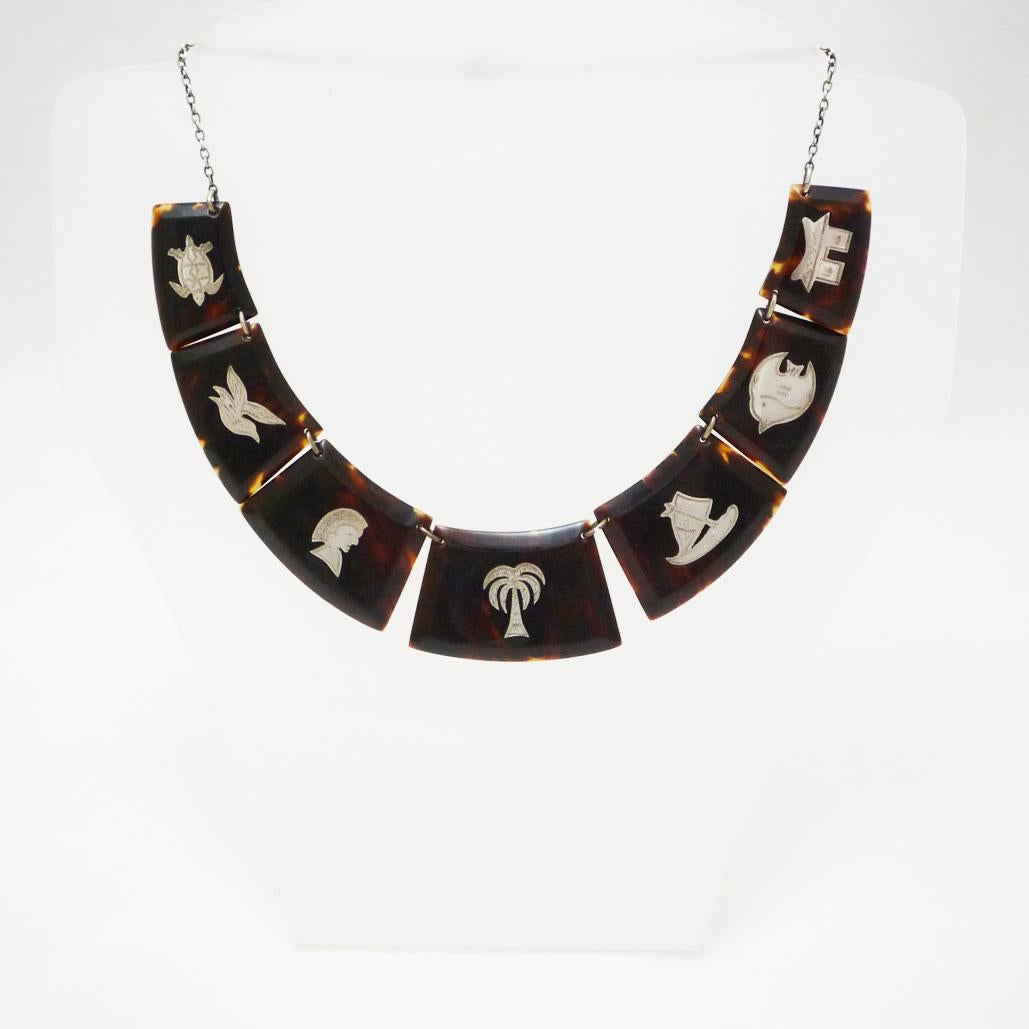 Collar Art Déco carey con incrustaciones de plata

Los adornos diseñados con motivos del antiguo Egipto confieren a este collar un aspecto noble y discretamente elegante.

Longitud de la cadena: 41 cm

Francia 1920-30