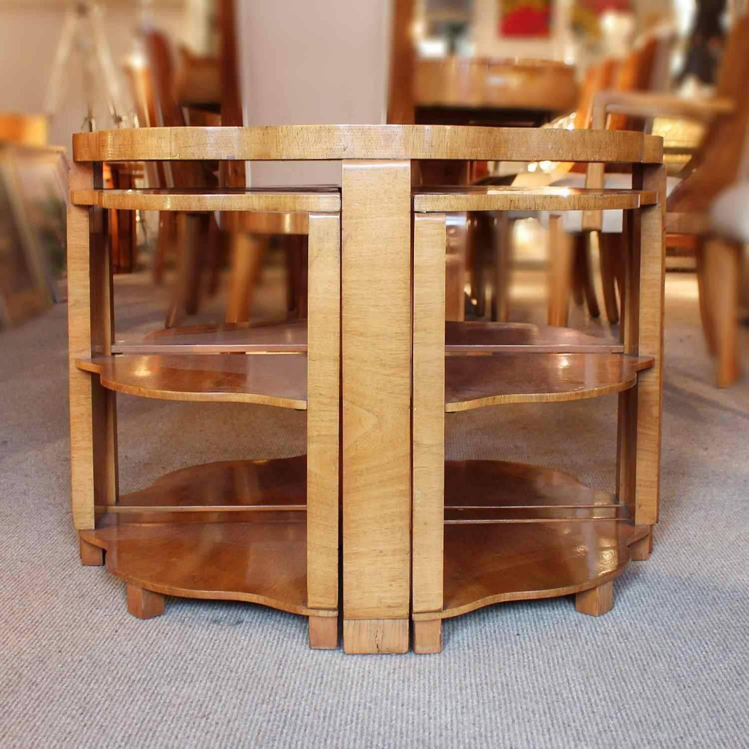 An Art Deco nest of tables in burr walnut. Main table with shaped edging set over cross footed base. Four shelved, integral side tables.

Dimensions: H 56cm, D 75cm, side tables H 48cm, W 48cm, D 33cm.

