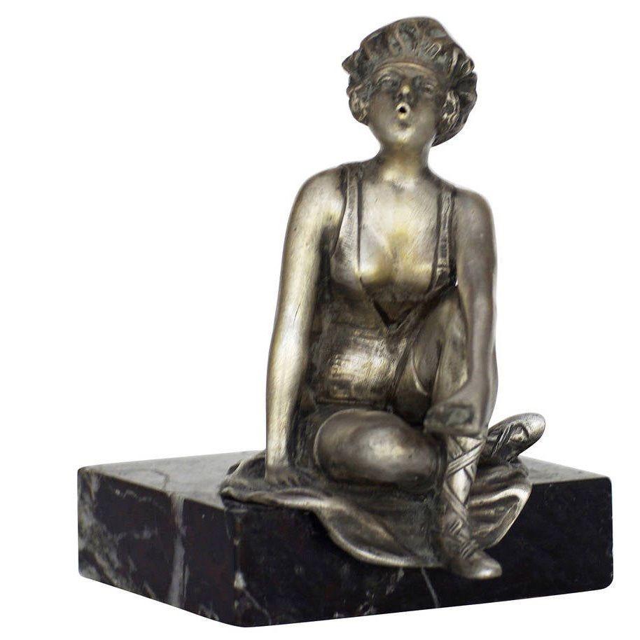 This Art Deco nickel plate features the statue of a young flapper smoking a cigarette; the statue is fixed to a black marble base. This is great example of early Art Deco design and is reminiscent of the design and quality found in Franz Xaver,