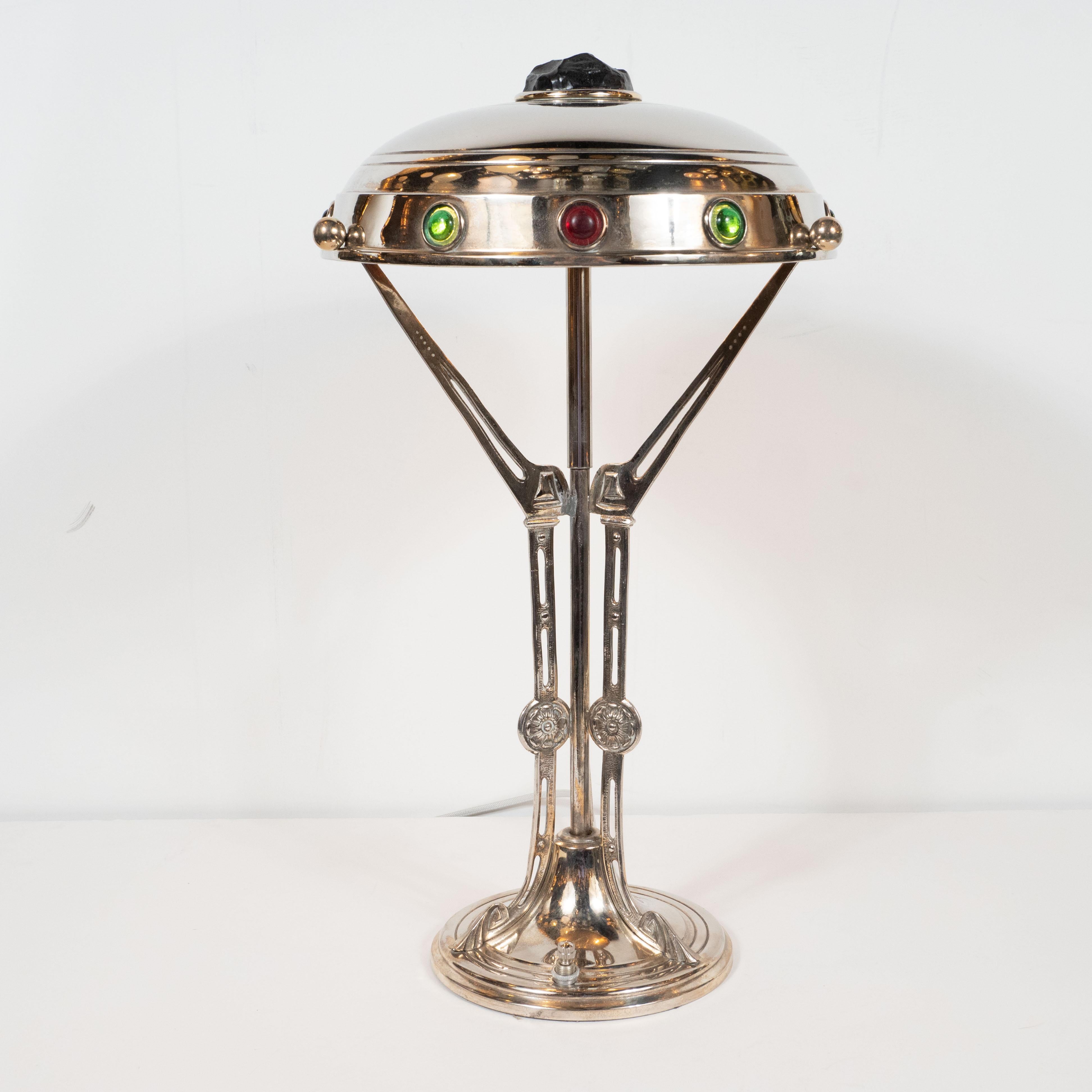 This stunning and dramatic table lamp was realized in Austria, circa 1920. This gorgeous piece features highly sculptural and beautifully crafted supports rising from a subtly domed and banded base- all realized in lustrous nickel. The domed shade
