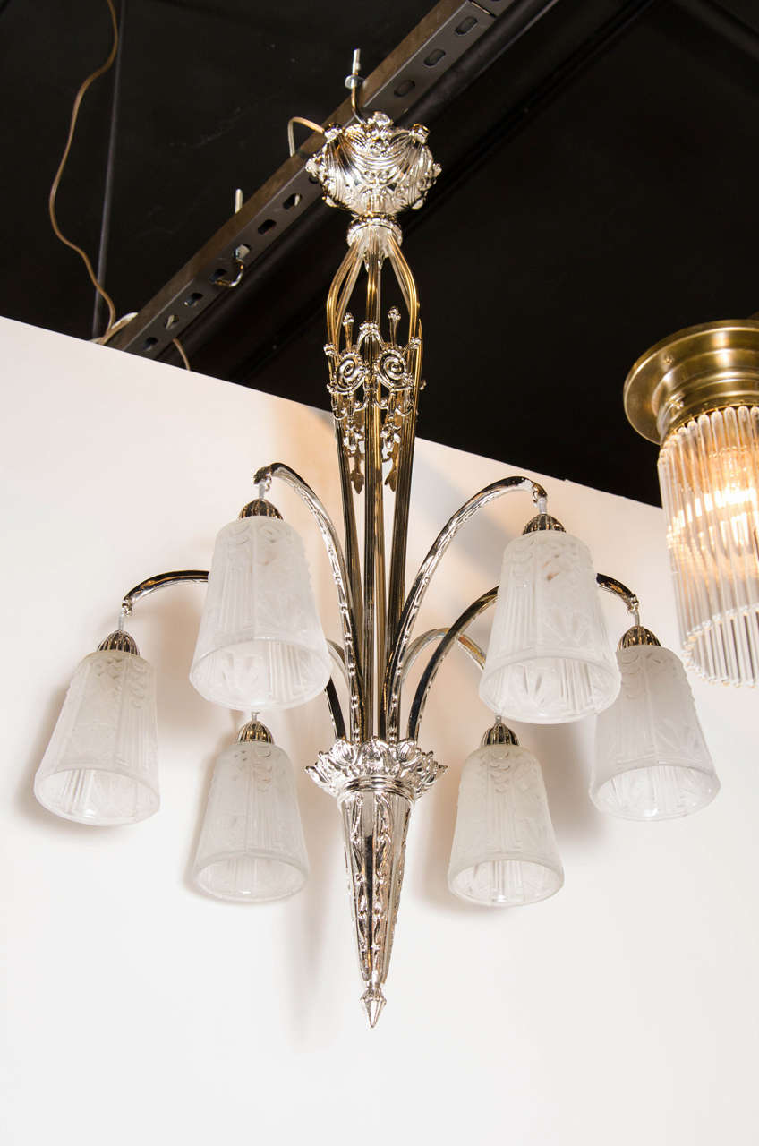This elegant chandelier was realized in France, circa 1930, by Muller Freres- one of the most celebrated lighting ateliers of the period. It features six conical globes in relief frosted glass with Art Deco cubist geometric designs engraved. The