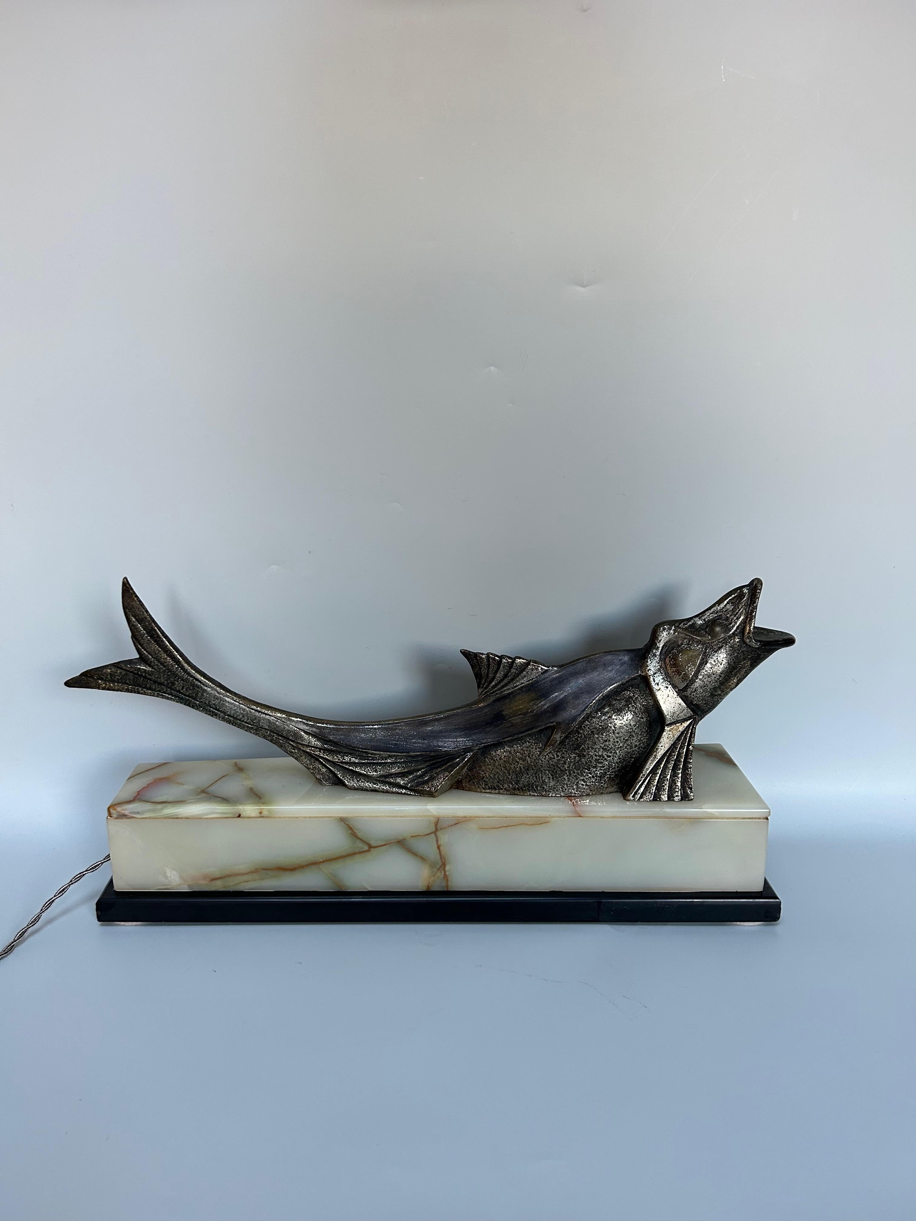 Scultura Art Deco del 1930 circa in babbitt argentato che rappresenta un pesce.
Base in onice illuminata (3 luci).
In ottime condizioni. Elettrificato.
Senza segno.

Altezza totale: 26,5 cm
Lunghezza: 54.5 cm
Larghezza: 13.5 cm
Peso: 13,5 cm