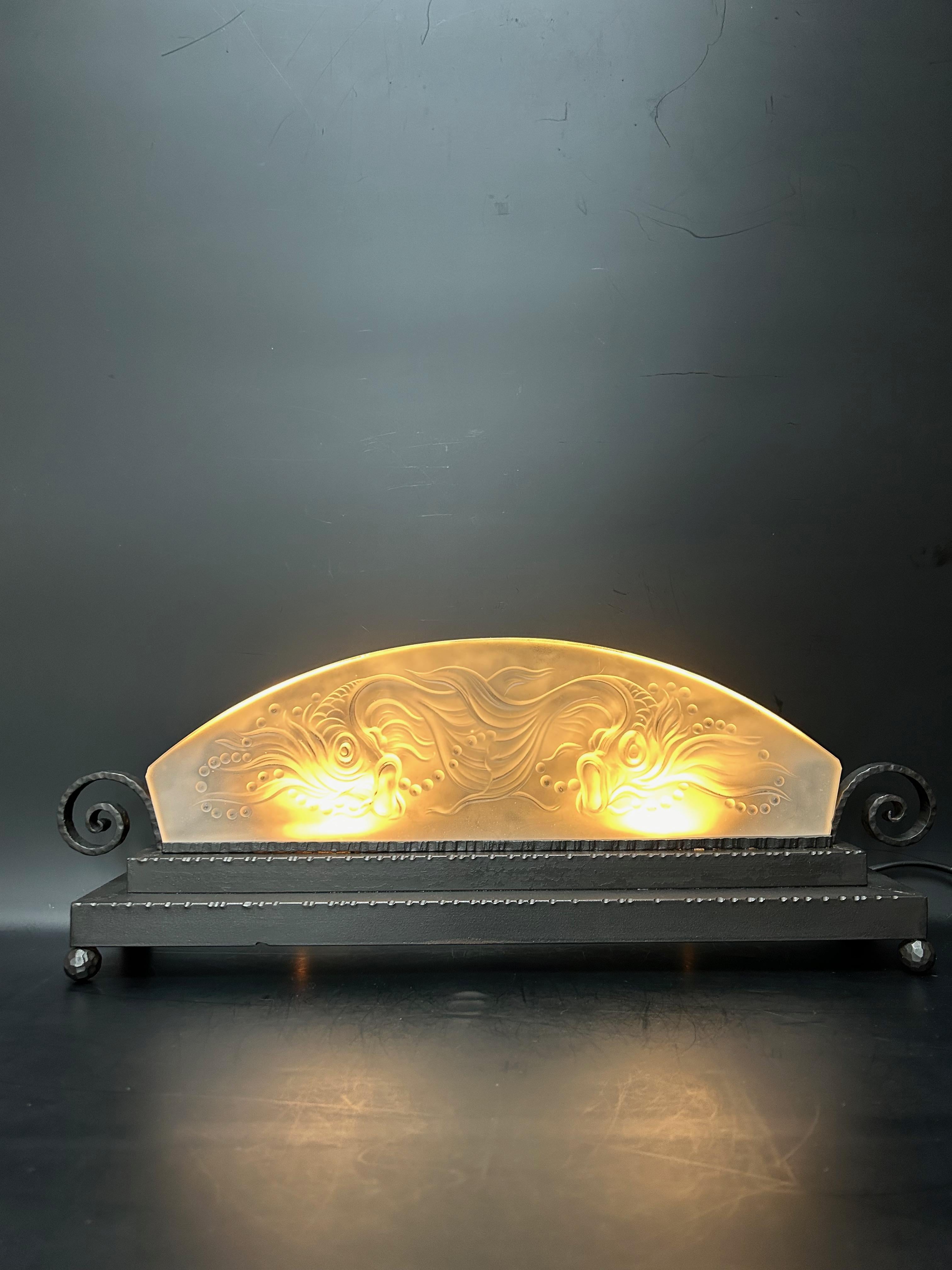 
Art deco night light circa 1930.
Wrought iron base, black patina. Molded glass plate with fish decoration.
Electrified and in perfect condition.
Molded signature “Boyreau Bordeaux”

Height: 20cm
Length: 55cm
Depth: 10cm
Weight: 3.5 kg

A. Boyreau