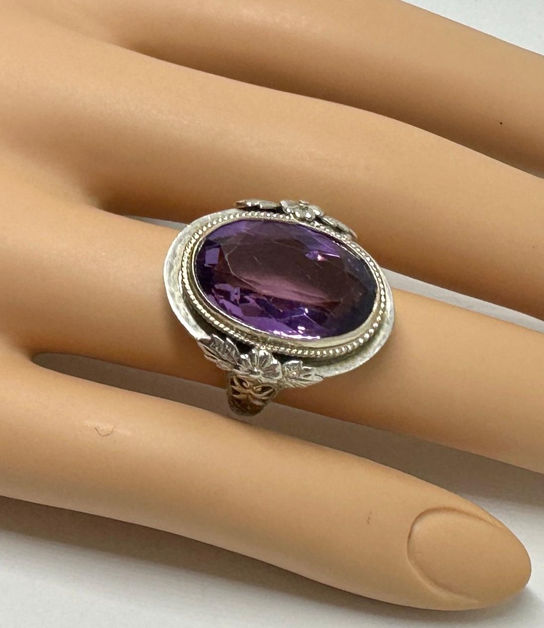 This is an extraordinary antique Art Deco Amethyst 14 Karat White Gold Ring with a stunning oval faceted natural Amethyst of approximately 9.2 Carats in a gorgeous filigree open work flower motif setting in 14 Karat White Gold.  The monumental