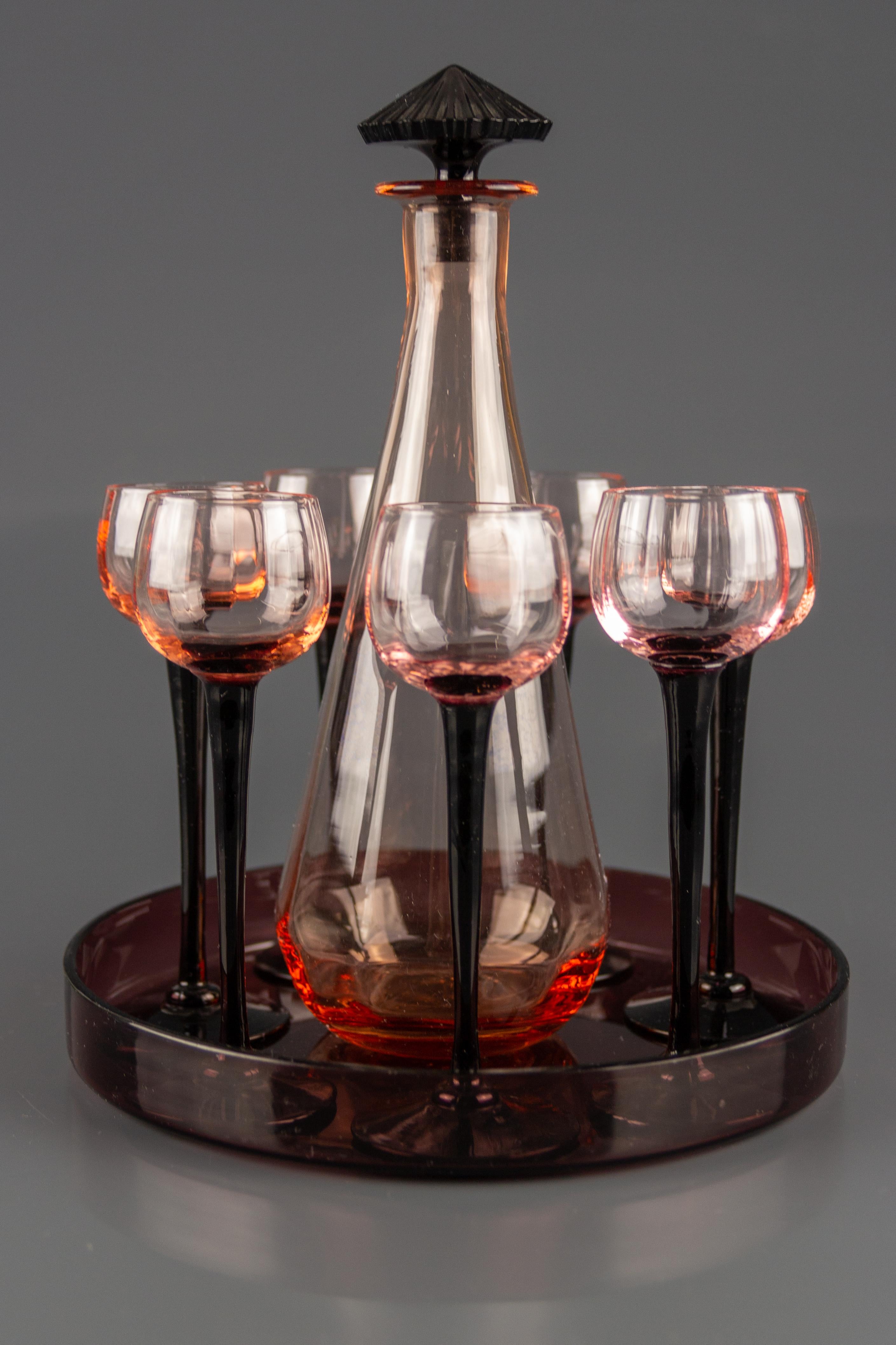 Adorable French Art Deco period liqueur set consisting of a decanter with stopper, seven glasses, and glass tray in smoky pink and dark purple color.
Dimensions: Height of the decanter 25 cm / 9.84 in, diameter of the tray 20 cm / 7.87 in, height