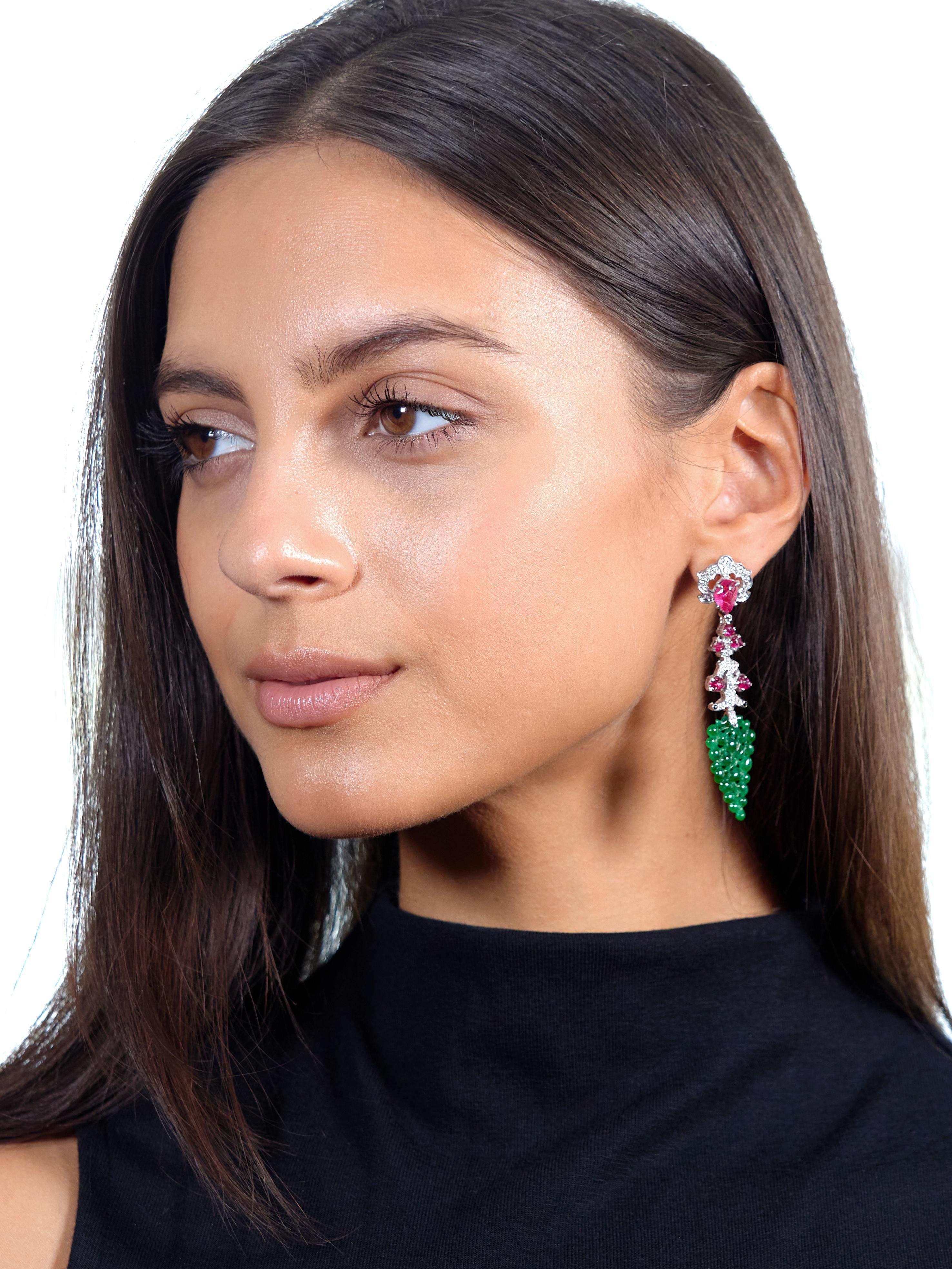 Designed as pierced open scrolling foliate motif surmounts suspending foliate branches and a bushel of grapes
Featuring Mogul style carved ruby cabochons depicting foliates and prong set throughout
Ranging in size from 3.0 x 2.5 mm to 6.0 x 9.0 mm -