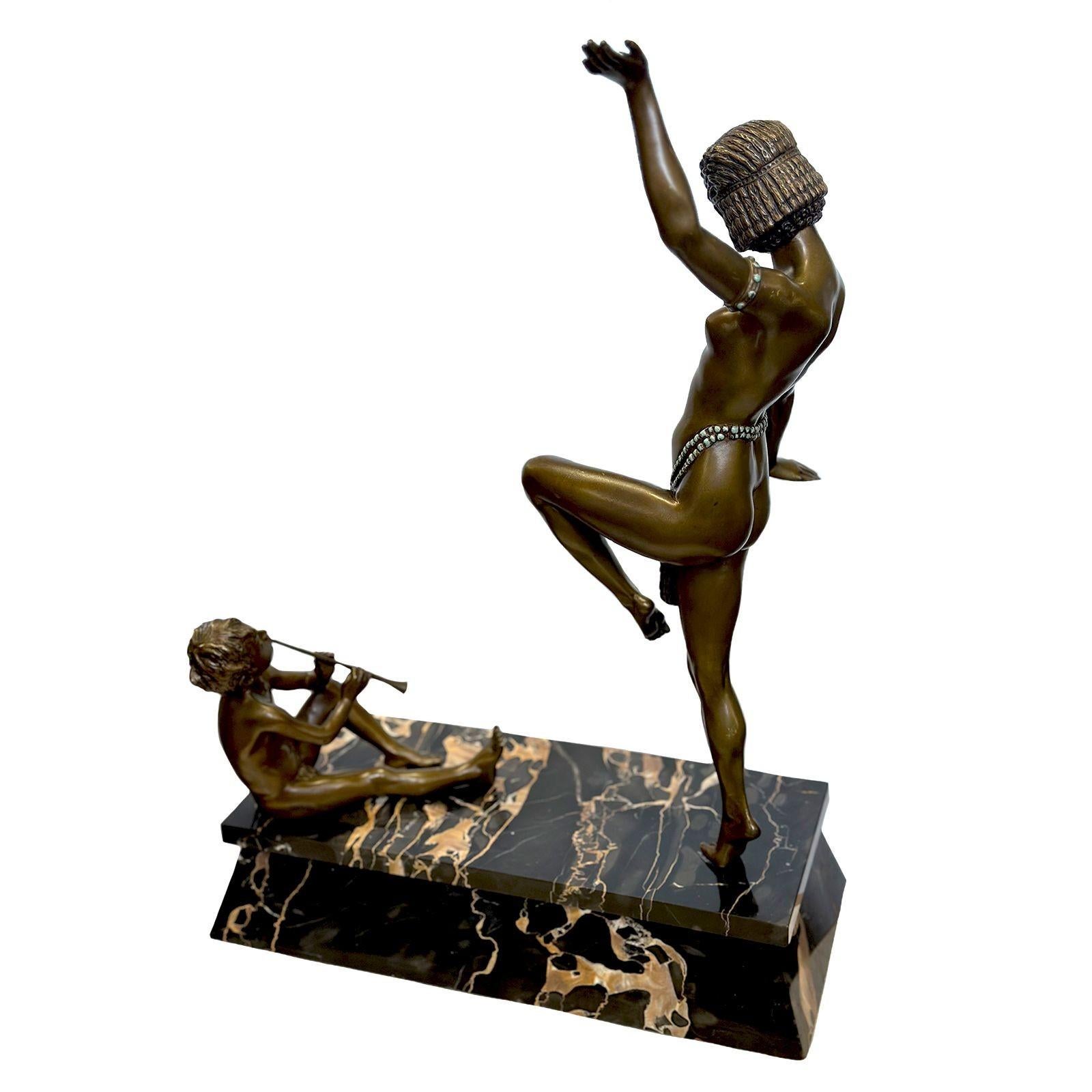 Splendida scultura in bronzo Art Deco raffigurante una danzatrice egiziana nuda che indossa uno slip succinto finemente decorato con smalto turchese. È anche adornata con braccialetti abbinati. Si vede anche un ragazzino seduto che suona il flauto
