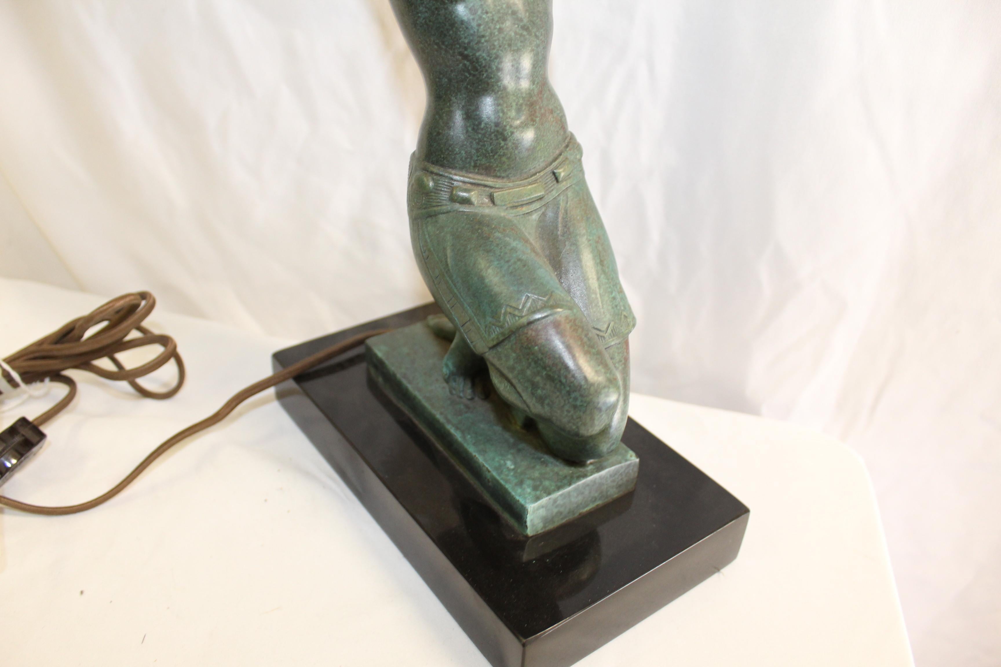 Deco girl lamp cast in Bronze with a green patina mounted on an absolute black marble base 8 1/4