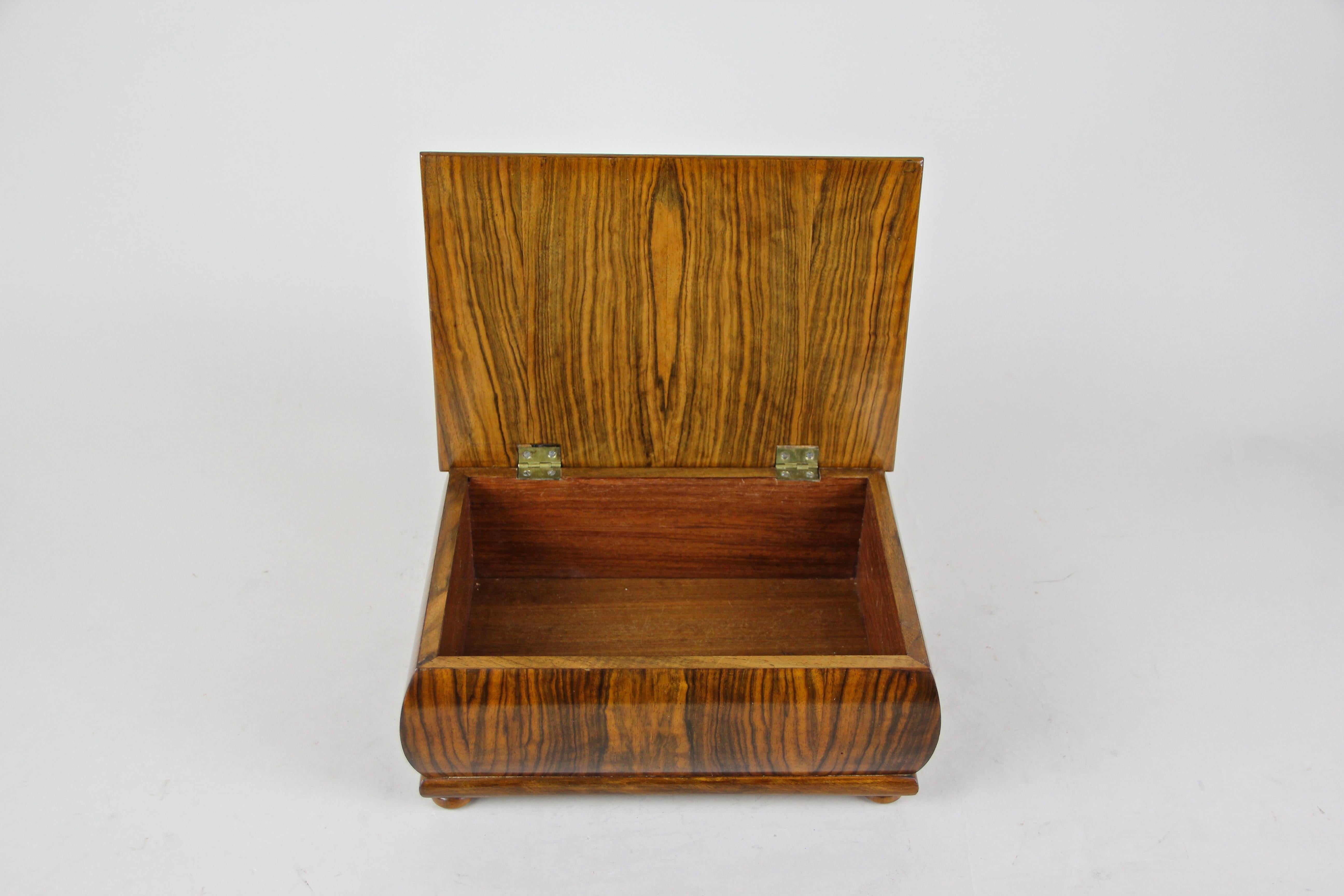 Decorative wooden Art Deco box with wonderful inlay work out of Austria, around 1920. Fine burl and nut wood veneer was arranged in a great manner to give this bulbous Art Deco box this unusual look. In the middle of the amazing book-matched burl