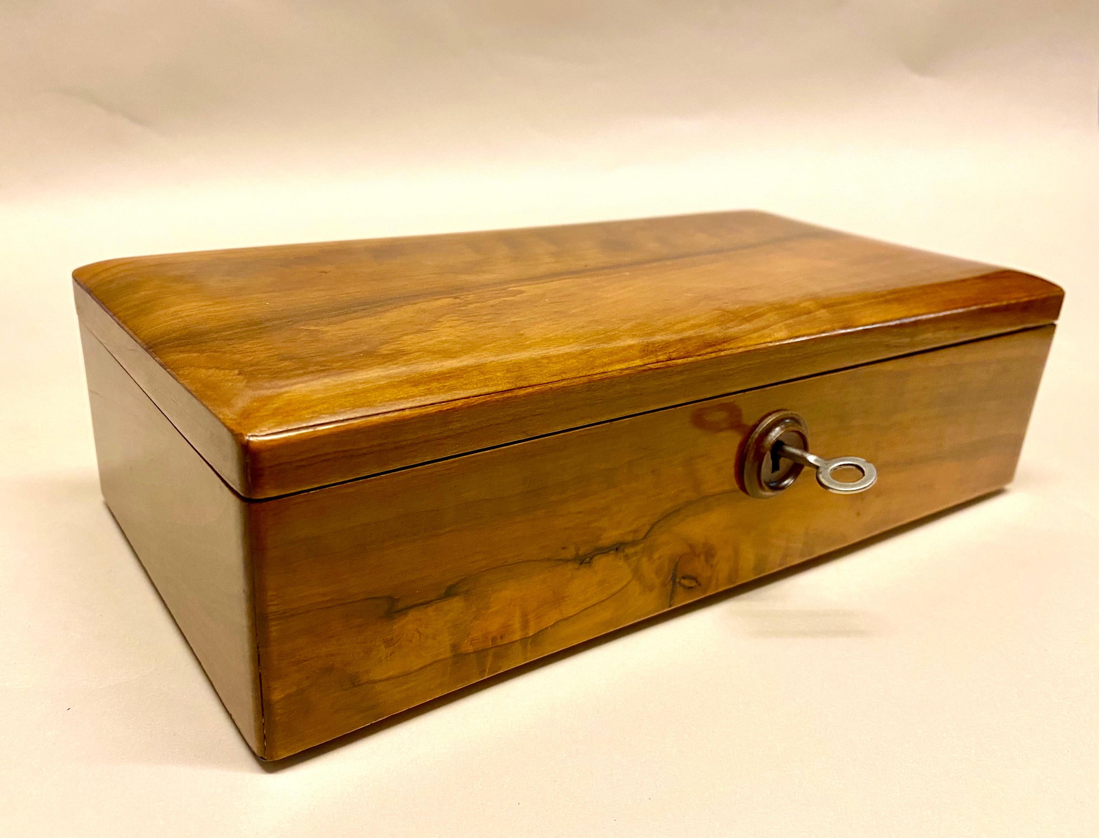 Delicate Art Deco nutwood box from the period around 1920 in Austria. Made of solid nutwood, this beautiful wooden box stands out with clear lines. The hinged lid can be locked with the original lock. A lovely carved wooden This decorative box comes