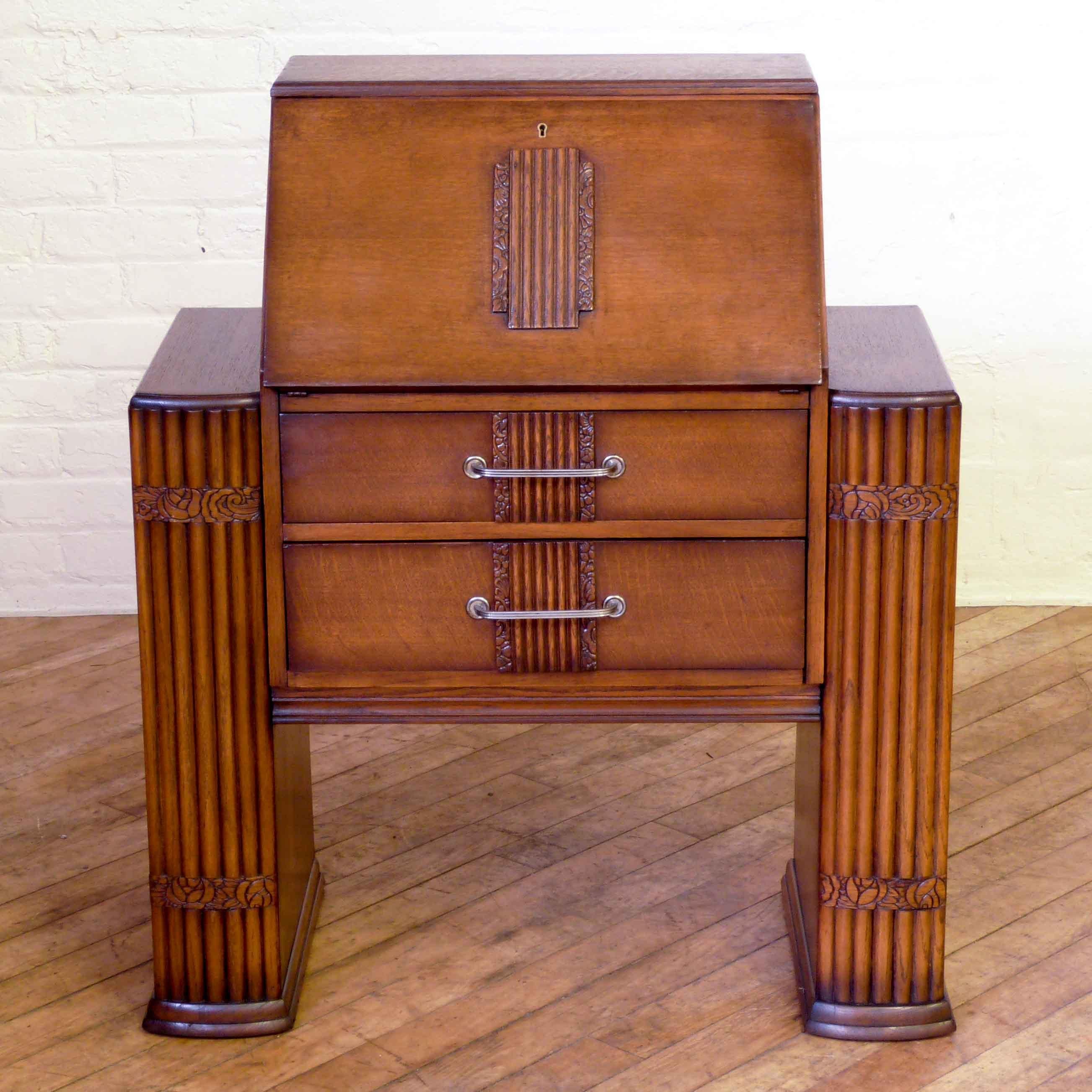 An Art Deco oak bureau of unusual design, with side bookcases. The fluted side pilasters are slightly bowed, typical of the Art Deco period as are the applied carvings to the fall and drawer fronts. Nice to see the original steel handles and working