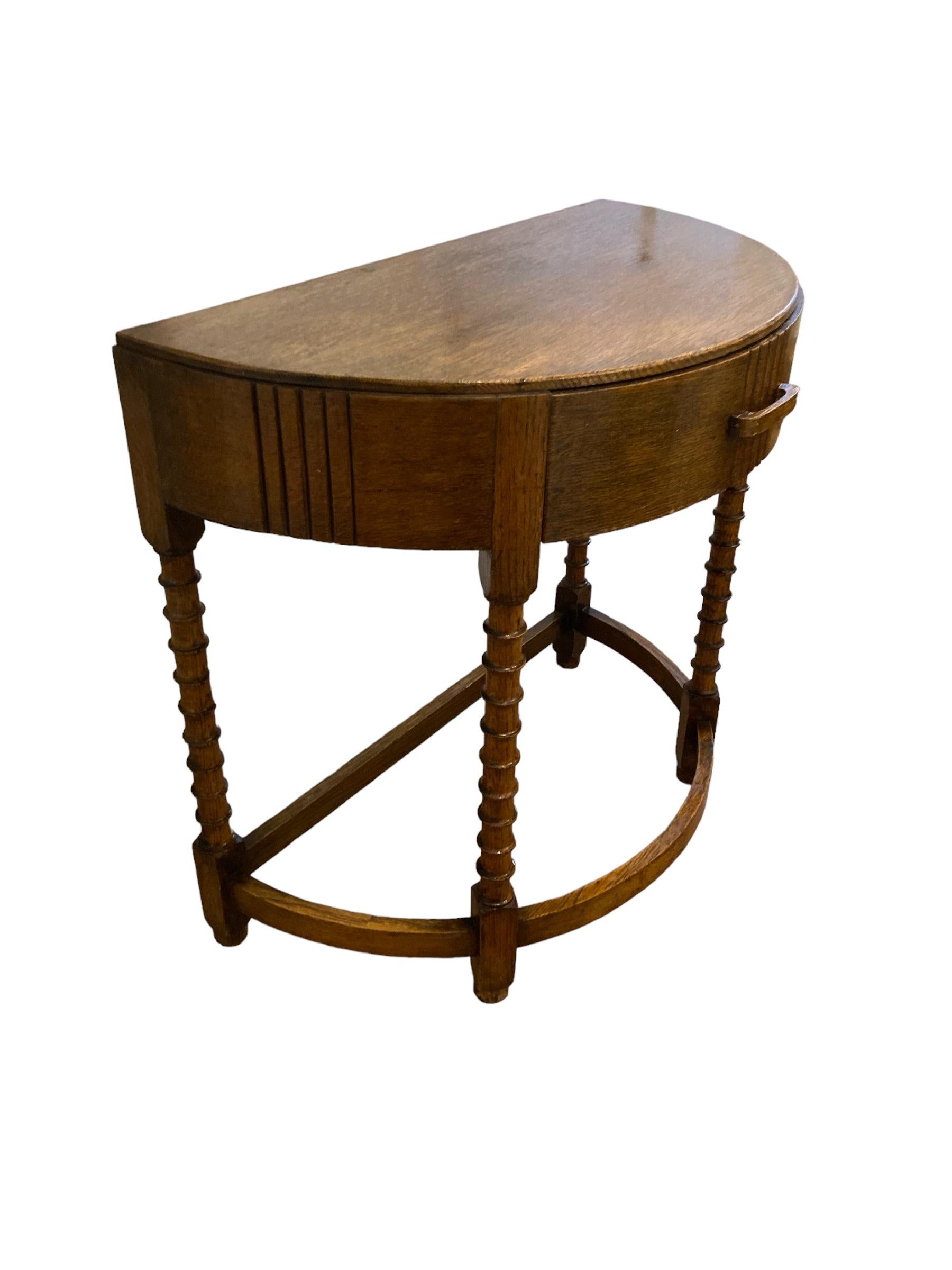 Unser eleganter Art Deco Half Moon Tisch mit einer wunderschön gearbeiteten Holzplatte und vier geschnitzten, stabilen Beinen, einer geschwungenen Streckbank und einer einzelnen Schublade ist ein vielseitiges Möbelstück, das Funktionalität mit Stil