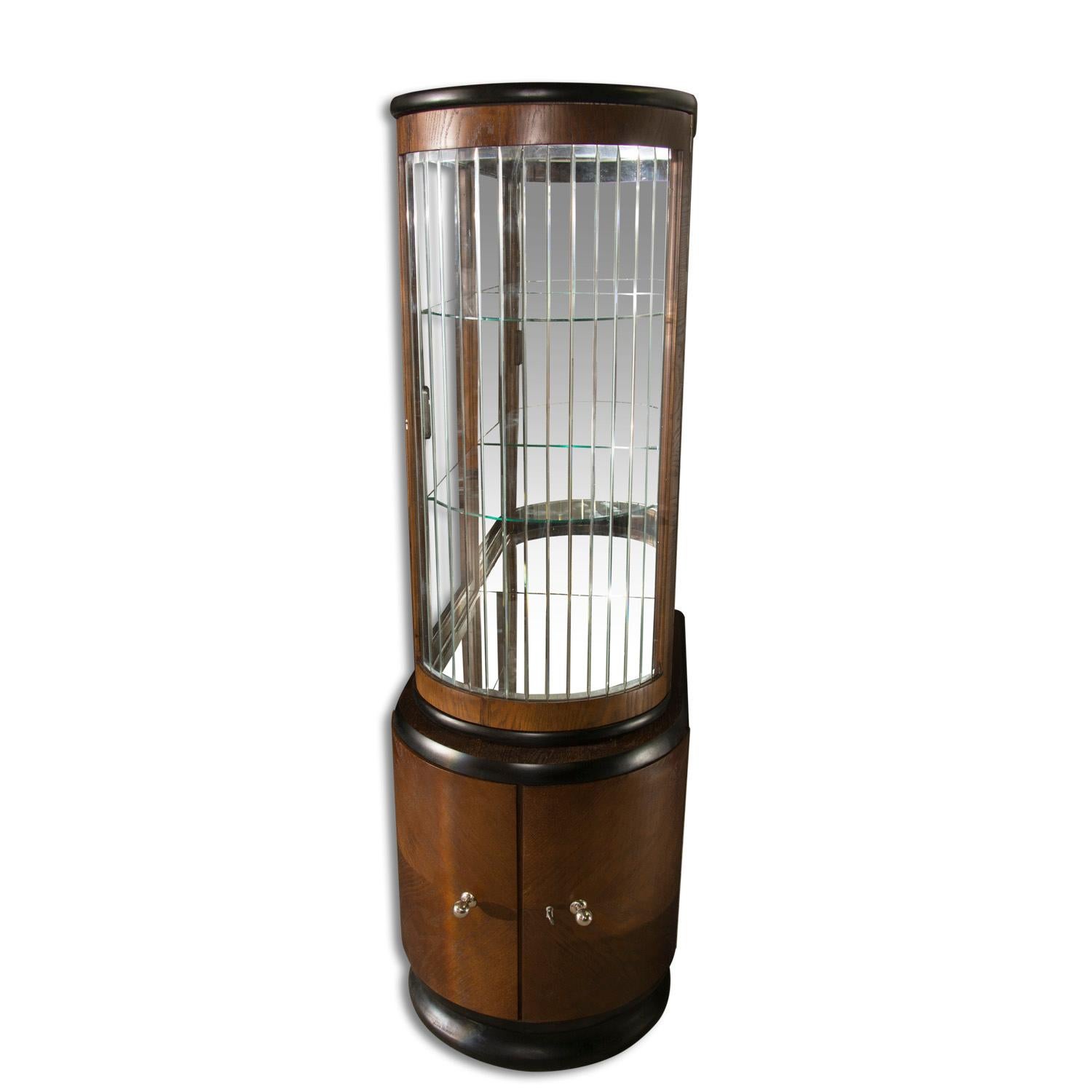 This narrow Art Deco liquor cabinet was made in Bohemia in the 1930s. It´s constructed in solid wood and veneer in oak.
It features a narrow profile sheathed by glass.
Chromed handles and a black lacquered base and top
Cabinet is in excellent