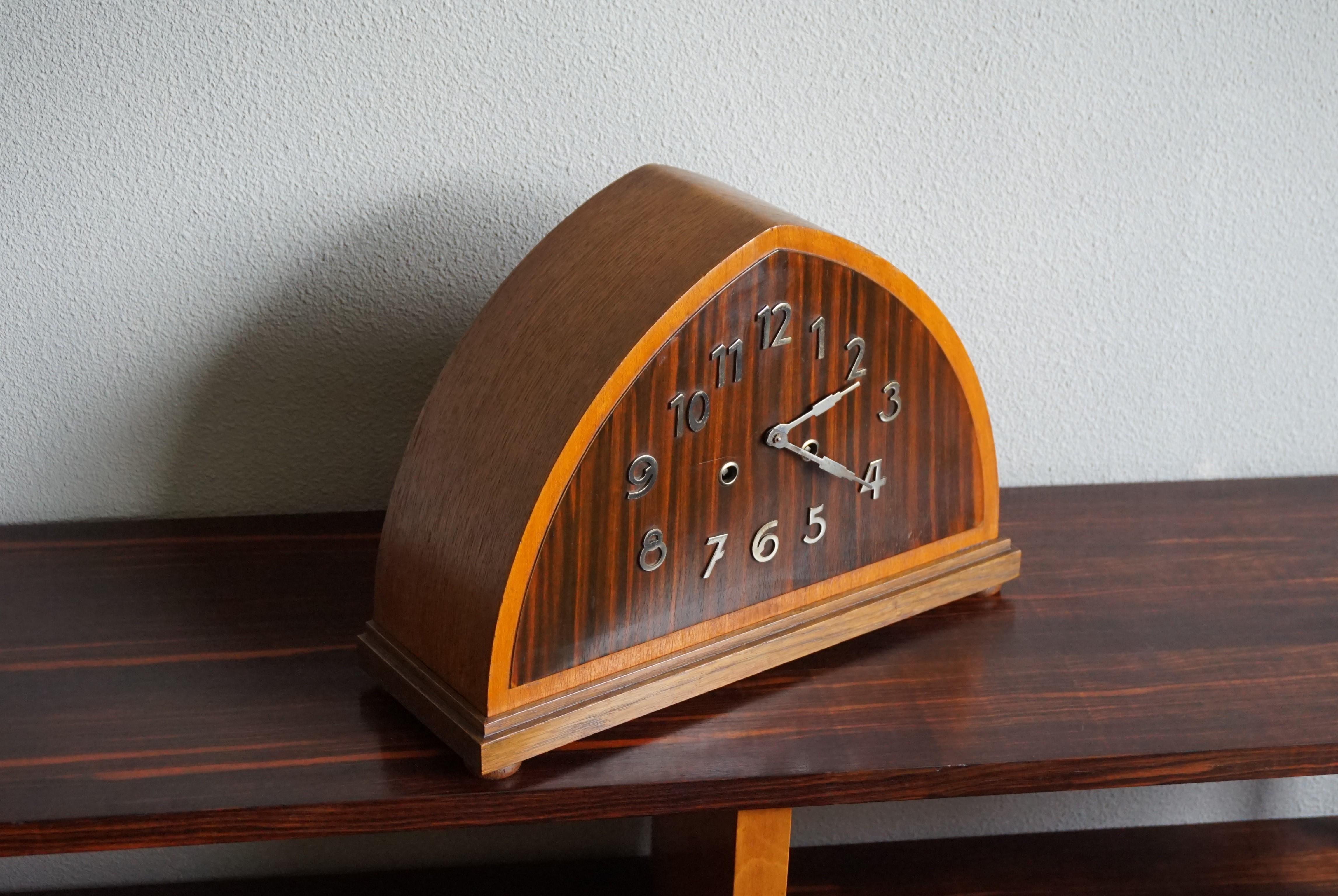 Beautiful design and perfectly working Art Deco clock with a chime.

If you are looking for a great shape and excellent condition clock then this original specimen from the 1920s could be perfect. The combination of the dark Cocobolo dial face