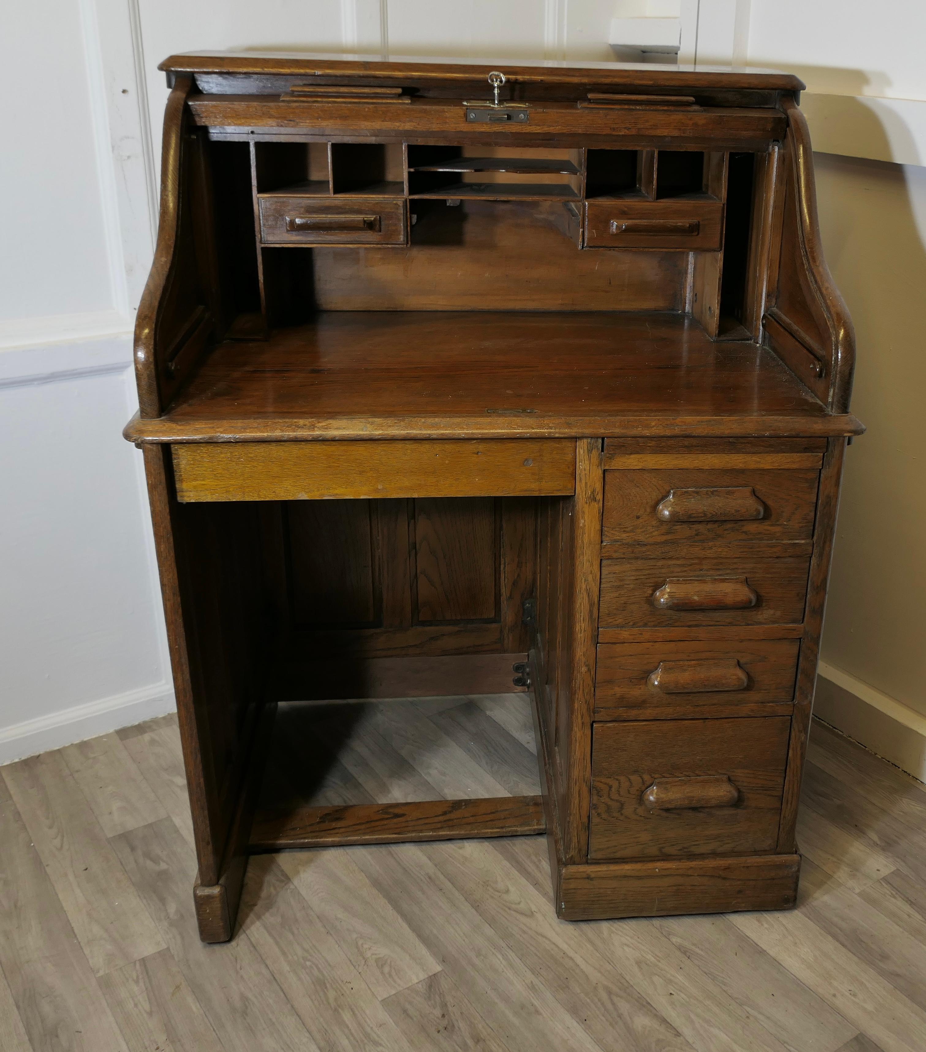  Art Deco Oak Roll Top Desk Restaurant Greeter  

This Oak restaurant greeting station has a roll top tambour which conceals beneath it a fitted interior of pigeon holes, card index drawers and stationary compartments
It has 4 graduated drawers down