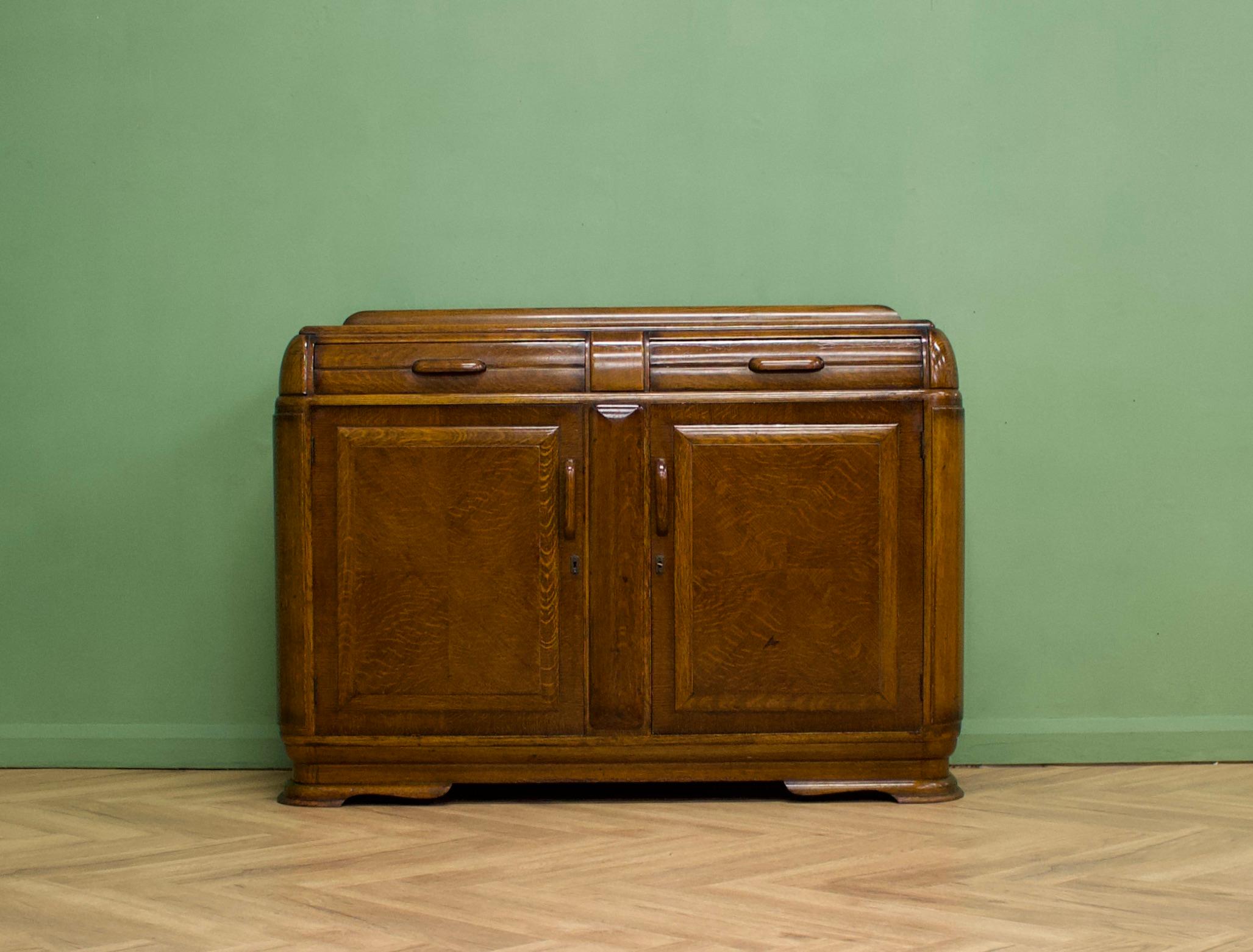 A high quality, dark oak Art Deco sideboard, circa 1930's-1940s
This piece is heavy and sturdy 
 
Featuring two drawers and two cupboards with shelves

