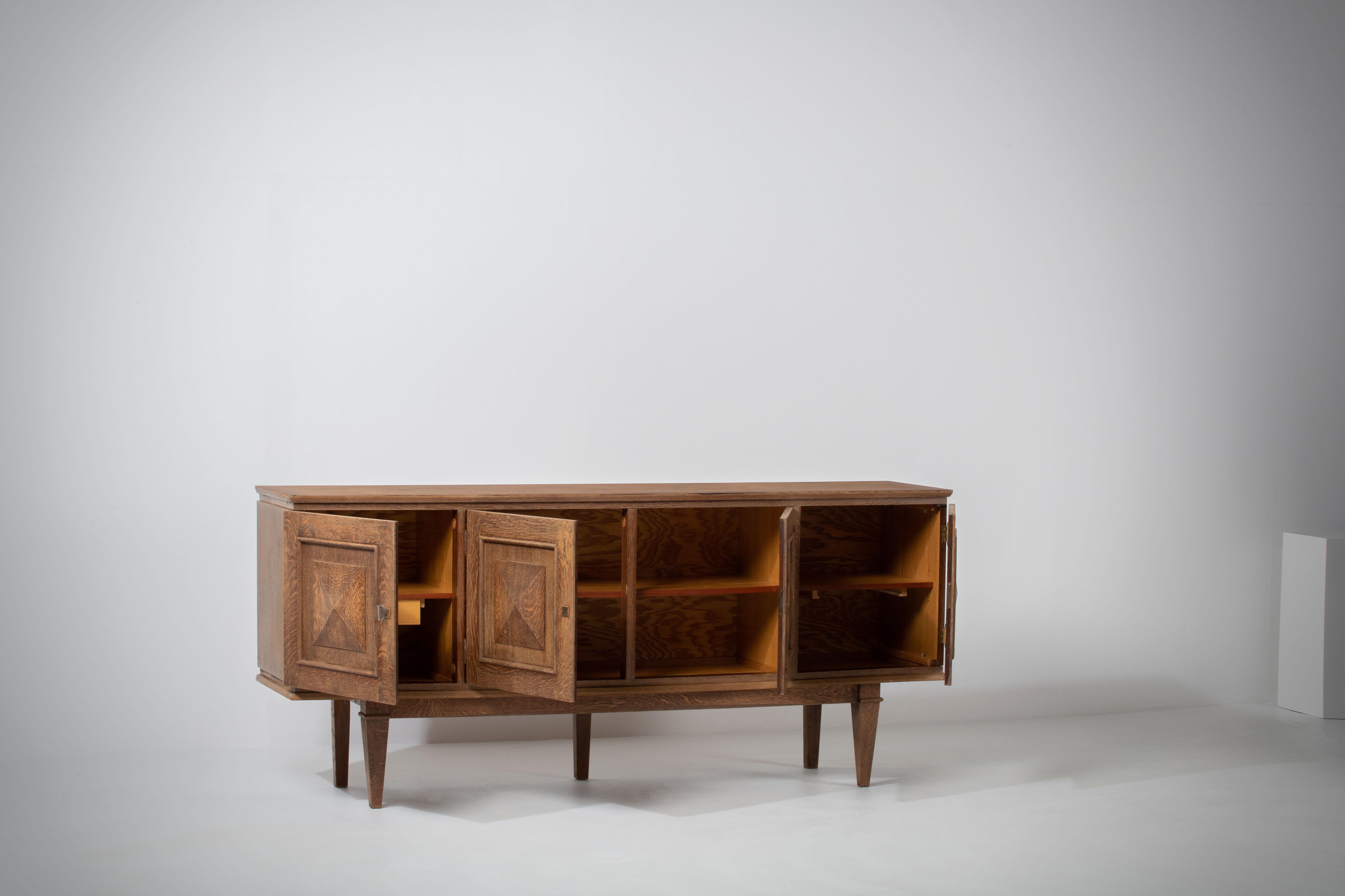 Credenza, solid oak, France, 1940s.
Large Art Deco Brutalist sideboard. 
The credenza consists of two storage facilities covered with very graphical designed door panels.
 