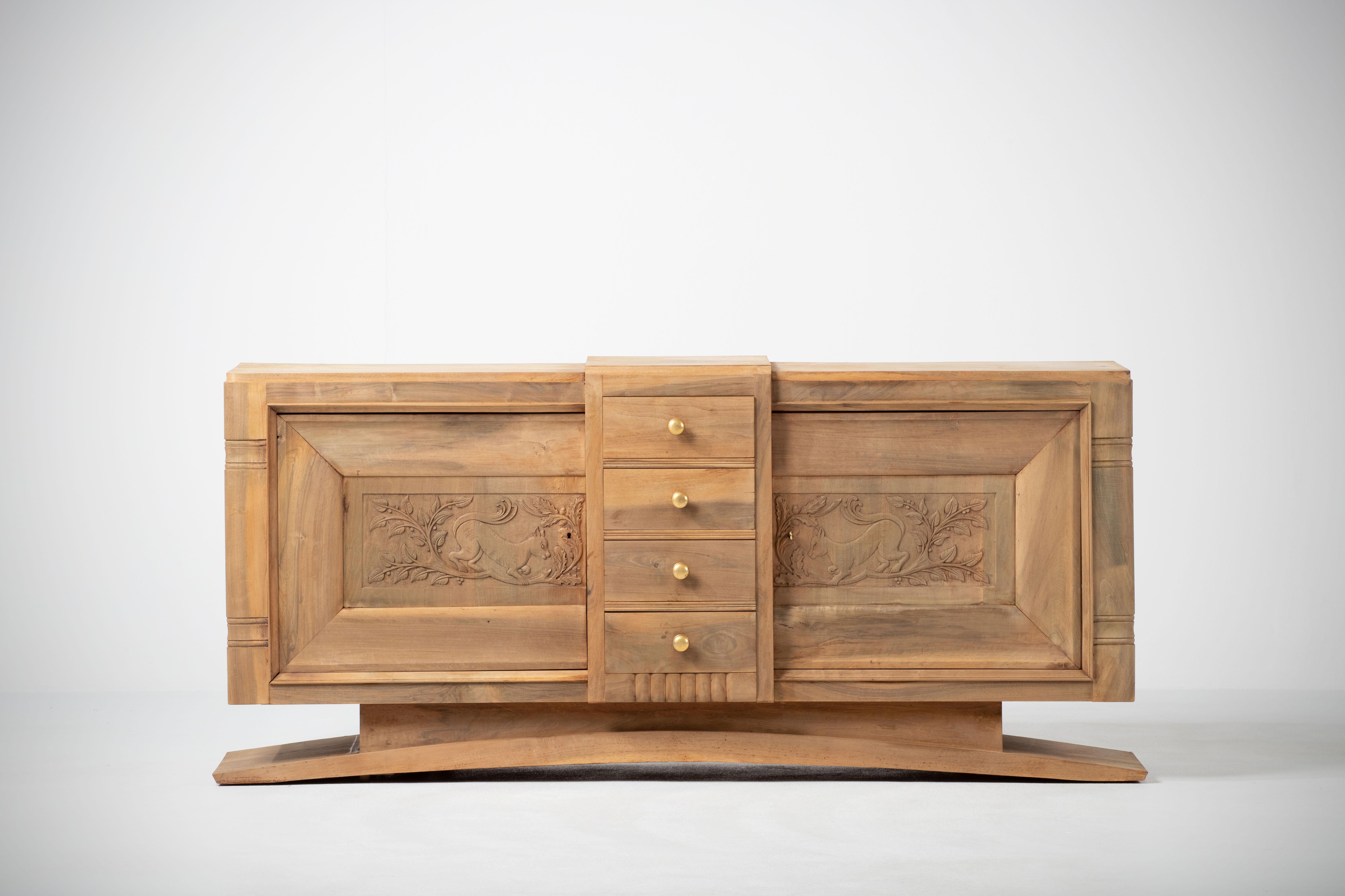 Credenza, solid oak, France, 1940s.
Large Art Deco Brutalist sideboard. 
The credenza consists of two storage facilities covered with very detailed designed door panels, in the center four drawers with brass handles.

