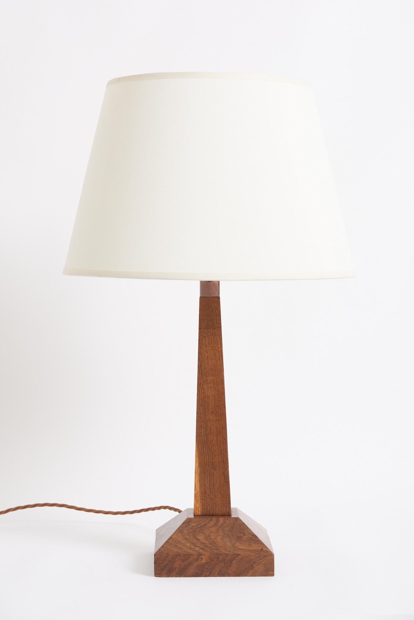 Art Deco Tischlampe aus Eiche
Frankreich, 1920er Jahre
Mit dem Schirm: 59,5 cm Höhe und 35,5 cm Durchmesser
Nur Lampenfuß: 43 cm hoch, 14,5 cm breit und 14,5 cm tief