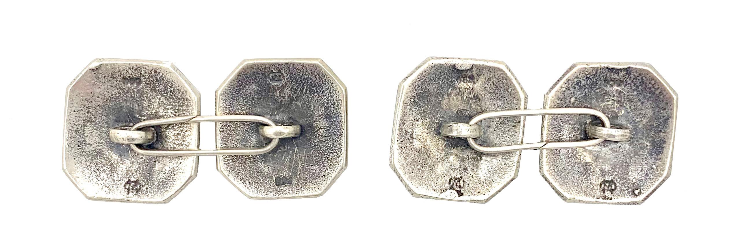 Thi s elegant pair of cufflinks features a raised carved leave design  on  a blackend background within a doubleedged octagonal boarder.
The litigated imaker's initials have yet to be identified. 
