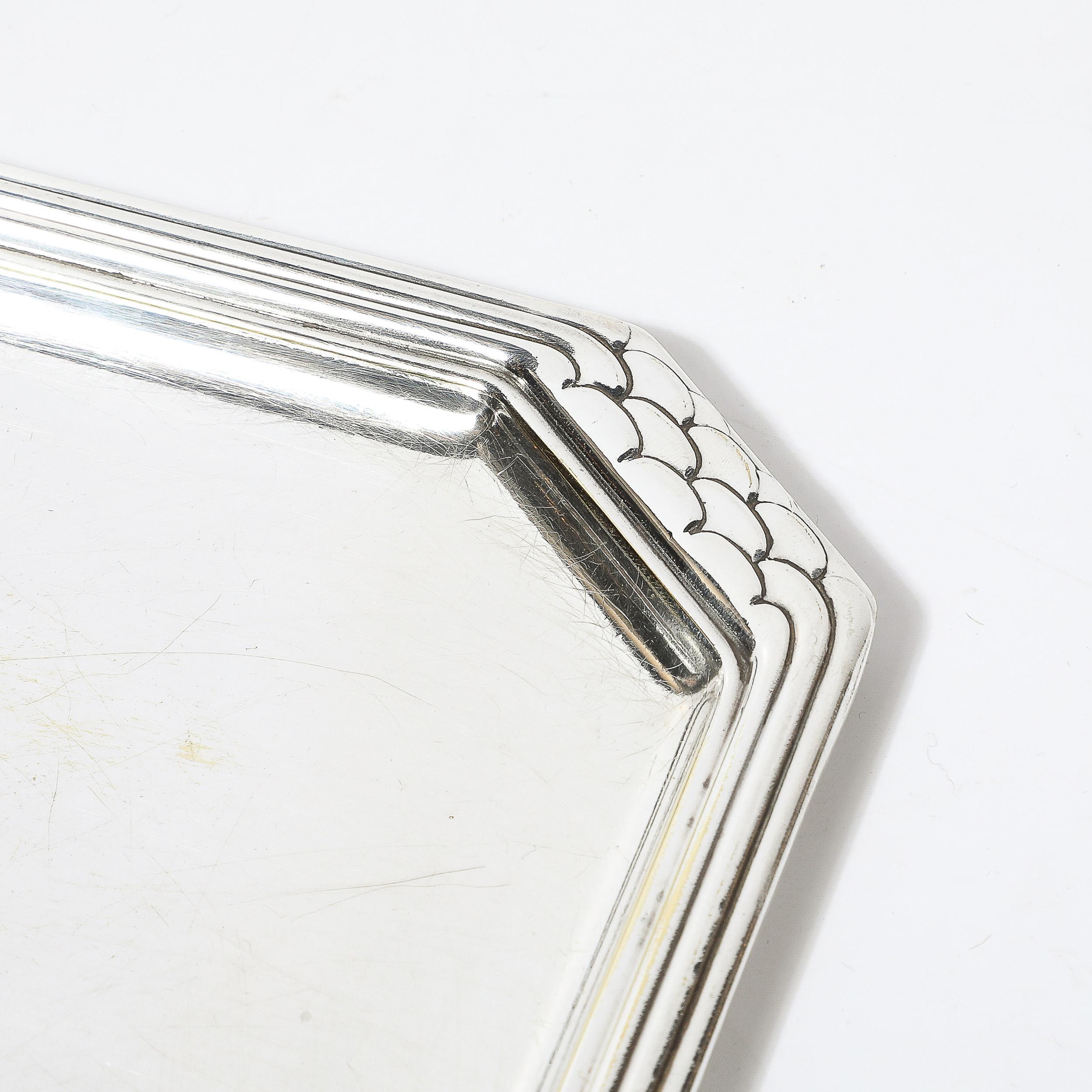 Mejora tu colección con esta Bandeja Art decó octogonal plateada con detalles imbricados, procedente de Francia hacia 1935. Esta llamativa pieza ejemplifica la elegancia y la precisión geométrica características del periodo Art Déco. La forma