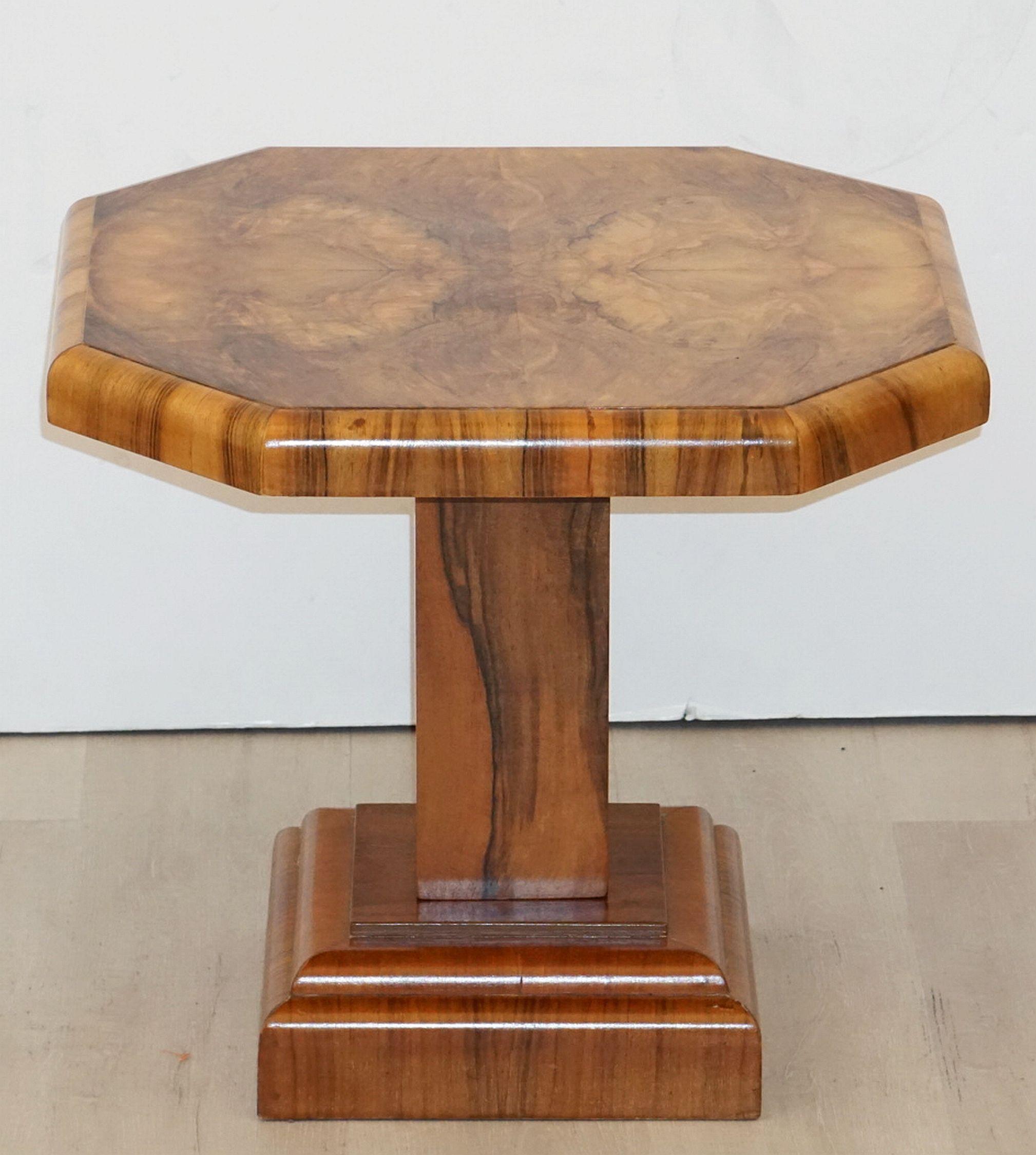 A fine English side table or occasional table from the Art Deco period, circa 1935, featuring an octagonal table top over a square walnut pedestal support and raised base. The whole with lovely figured veneers of burled walnut.