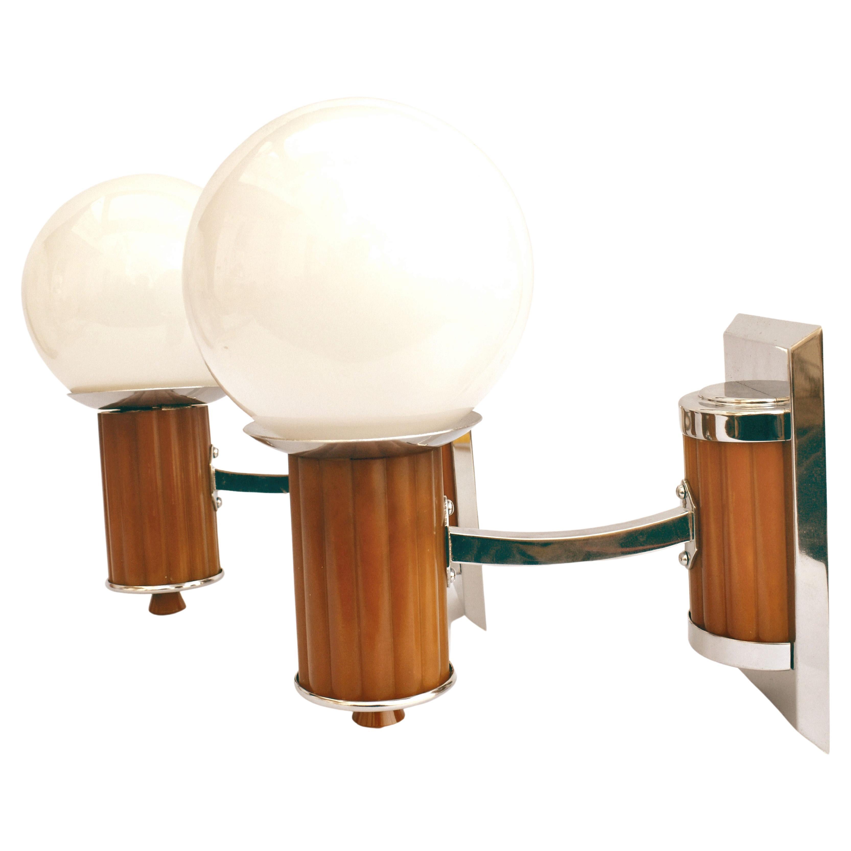 A very rare chance to acquire a pair of matching Art Deco wall light sconces. Made from butterscotch coloured catalin/phenolic Bakelite and newly re-chromed metal-ware with white milk coloured globe shades. These lights make a great statement to any