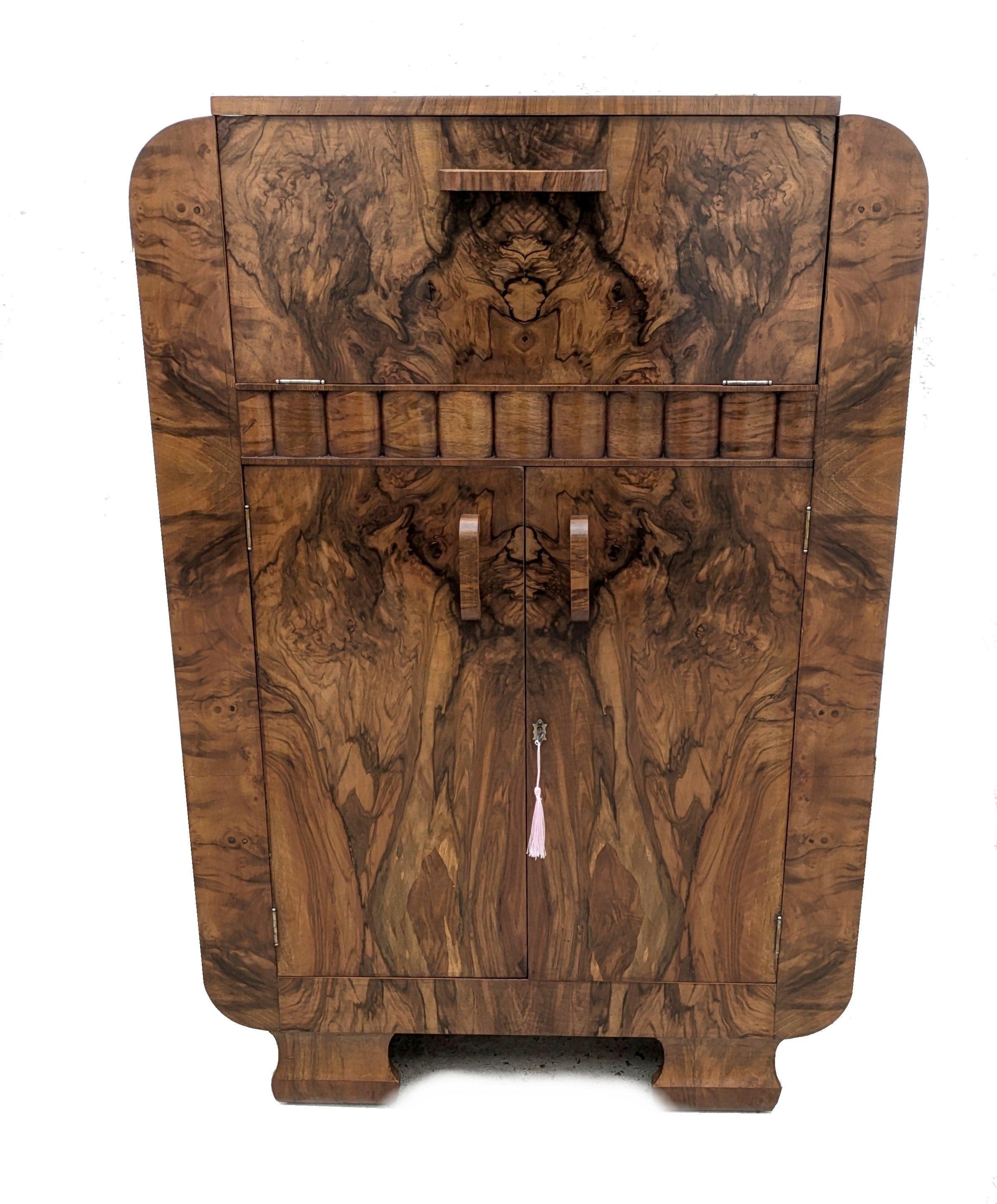 For your consideration is this fabulously stylish 1930's Art Deco cocktail cabinet. This dry bar dates to the 1930's and has all the bells and whistles you want from a cocktail cabinet. The upper interior has a mirrored base and mirrored backing .