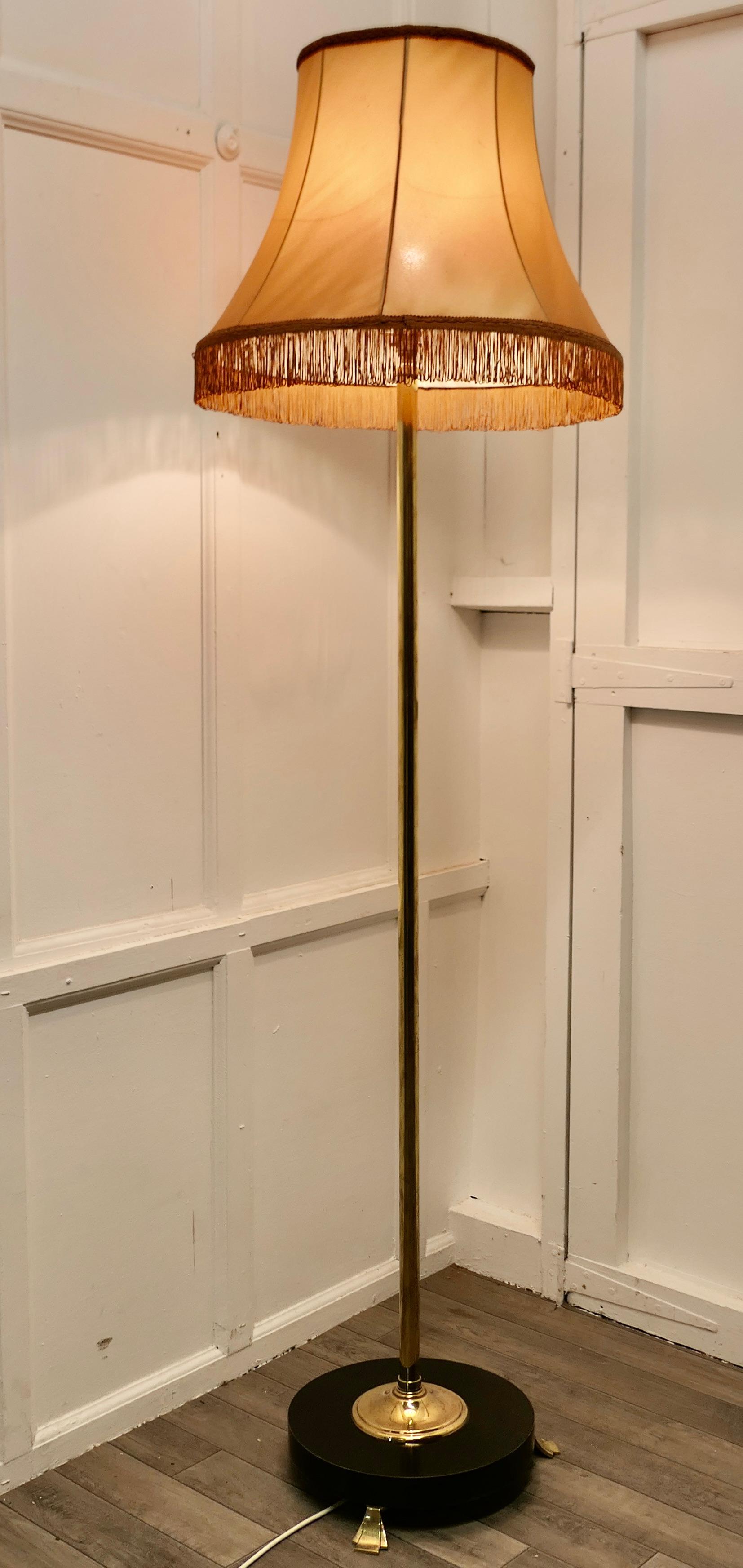 Art Deco Odeon style black and brass standard or floor lamp

This is a very stylish piece, the base of the lamp is a thick ebonised wooden round set on brass feet supporting a tall brass column 
The lamp is in good condition, working and comes