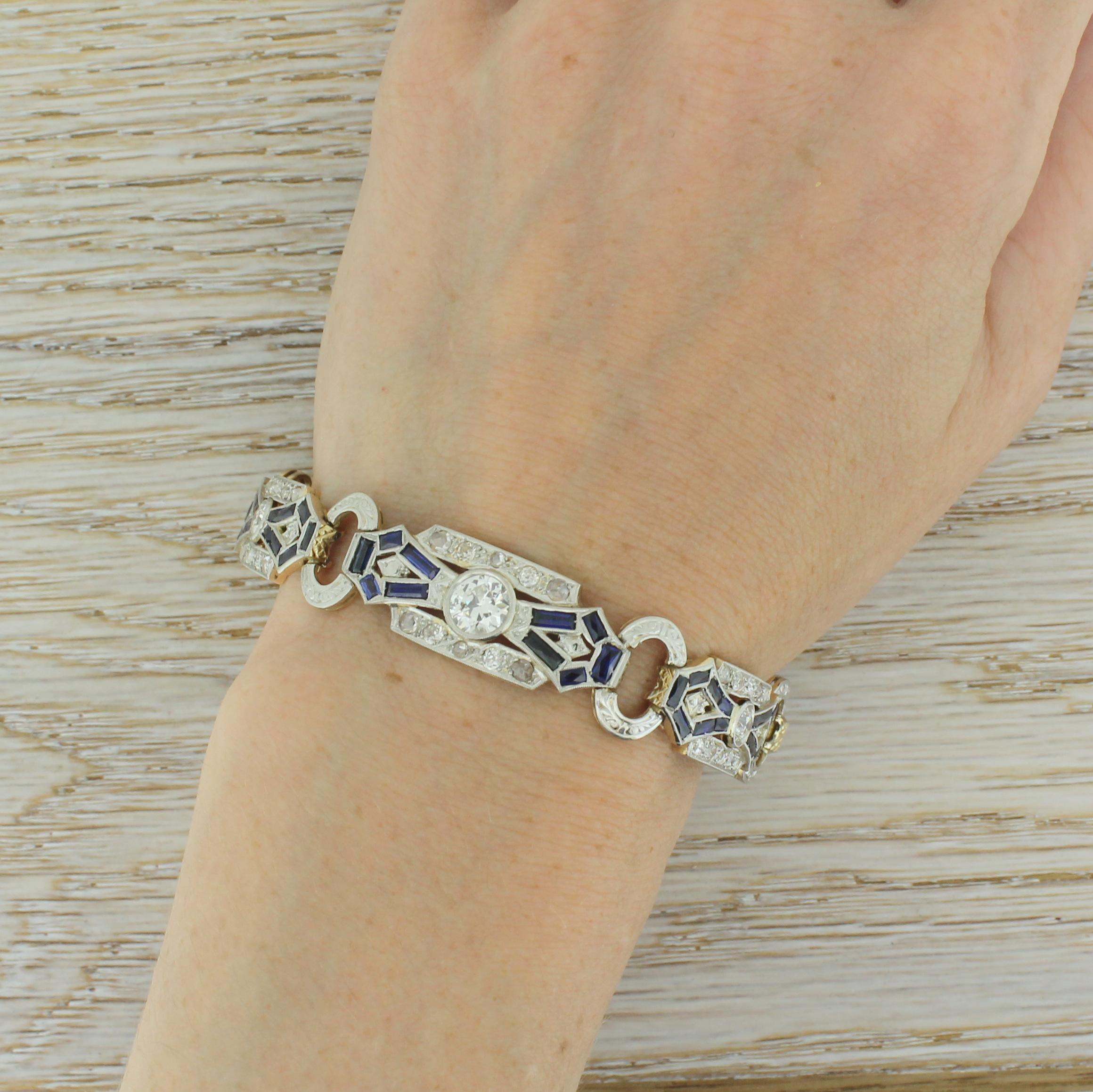 Supremely beautiful. This breathtaking bracelet is formed of five diamond and sapphire set panels, connected by engraved oval links. Each panel is centred by a rubover set old cut diamond – graduating to a 0.91 carat stone in the middle panel – and