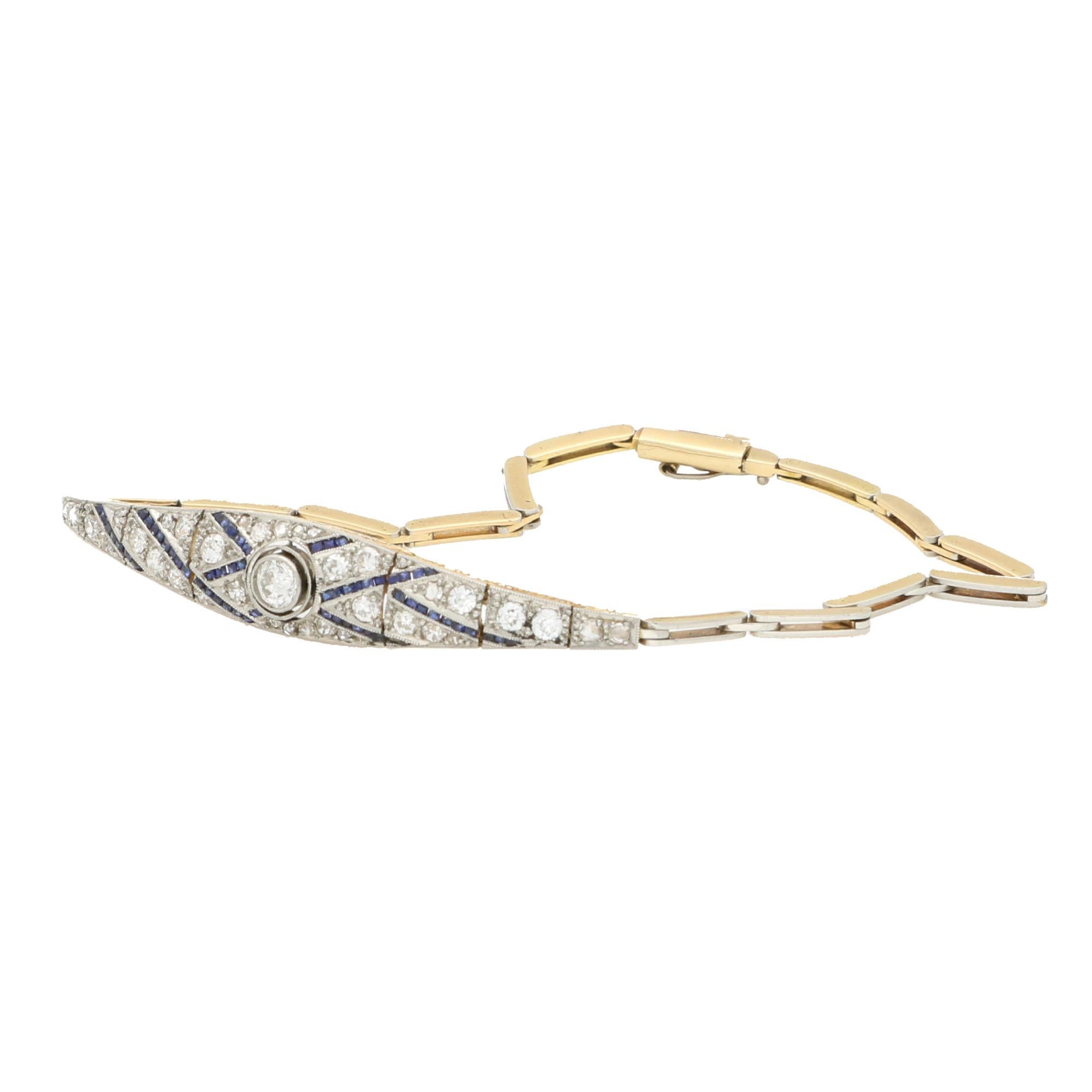 A beautiful Art Deco old cut diamond and blue sapphire panel bracelet set in 18k yellow gold and platinum. 

The panel is centrally set with a 0.25 carat old cut diamond, amongst a cross over pattern of channel set blue sapphires and diamonds. The