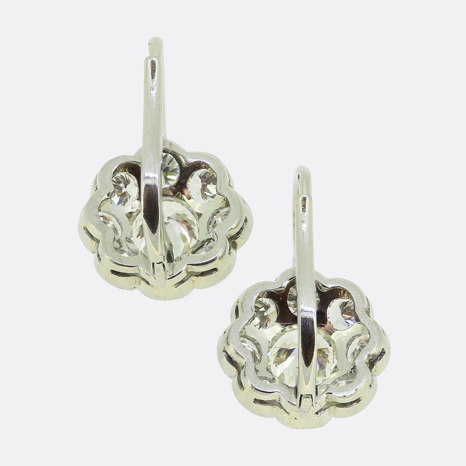 Nous avons ici une exquise paire de boucles d'oreilles en forme de grappe, fabriquées à l'apogée du mouvement Art déco. Ces boucles d'oreilles présentent un superbe arrangement de diamants de taille européenne ancienne, avec une pierre centrale